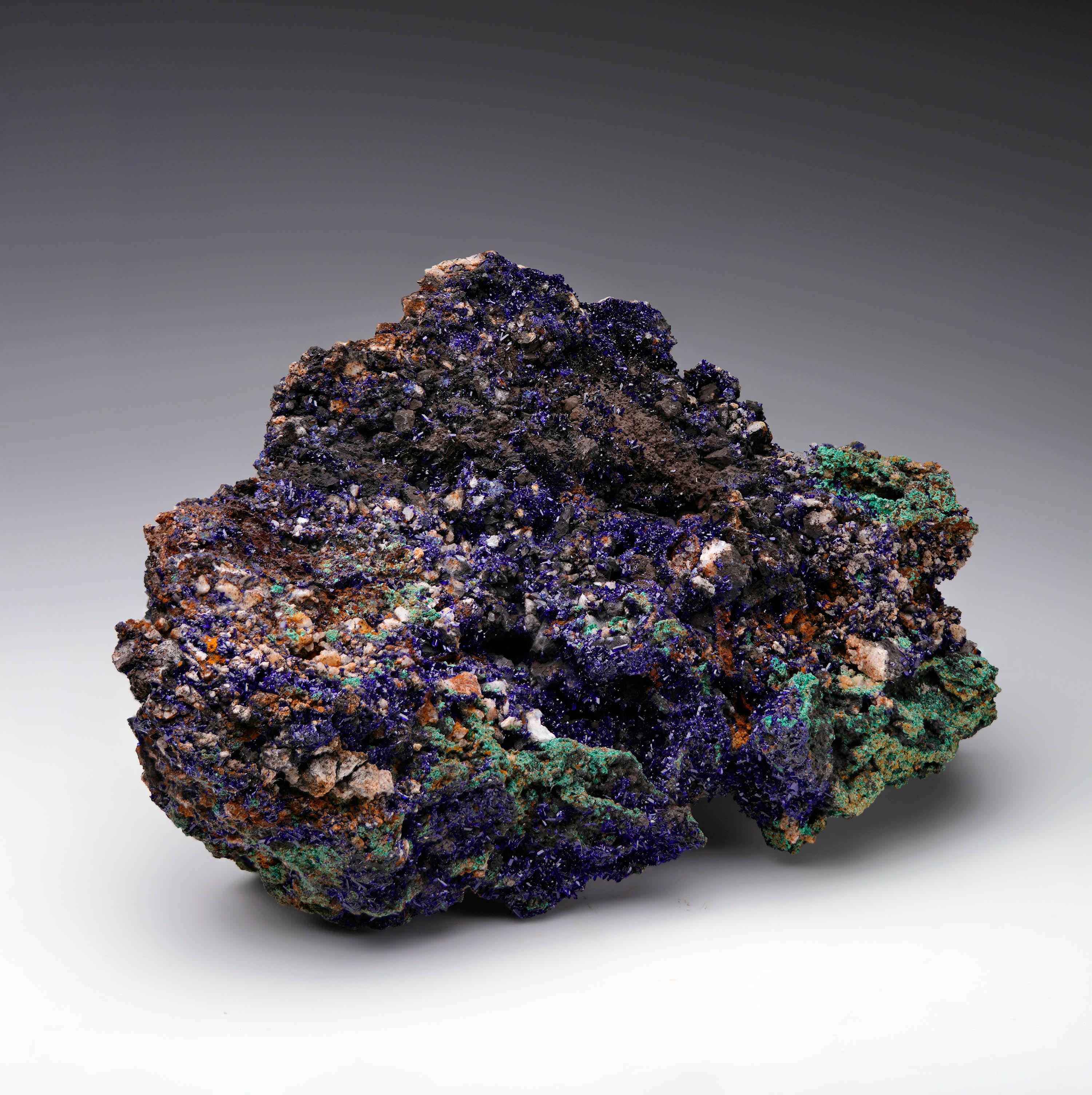 Cet éblouissant spécimen d'azurite et de malachite offre un kaléidoscope de bleus profonds et pigmentés et de verts forestiers vibrants sur une matrice richement texturée. Les cristaux d'azurite brillent d'une saturation et d'un éclat intenses,