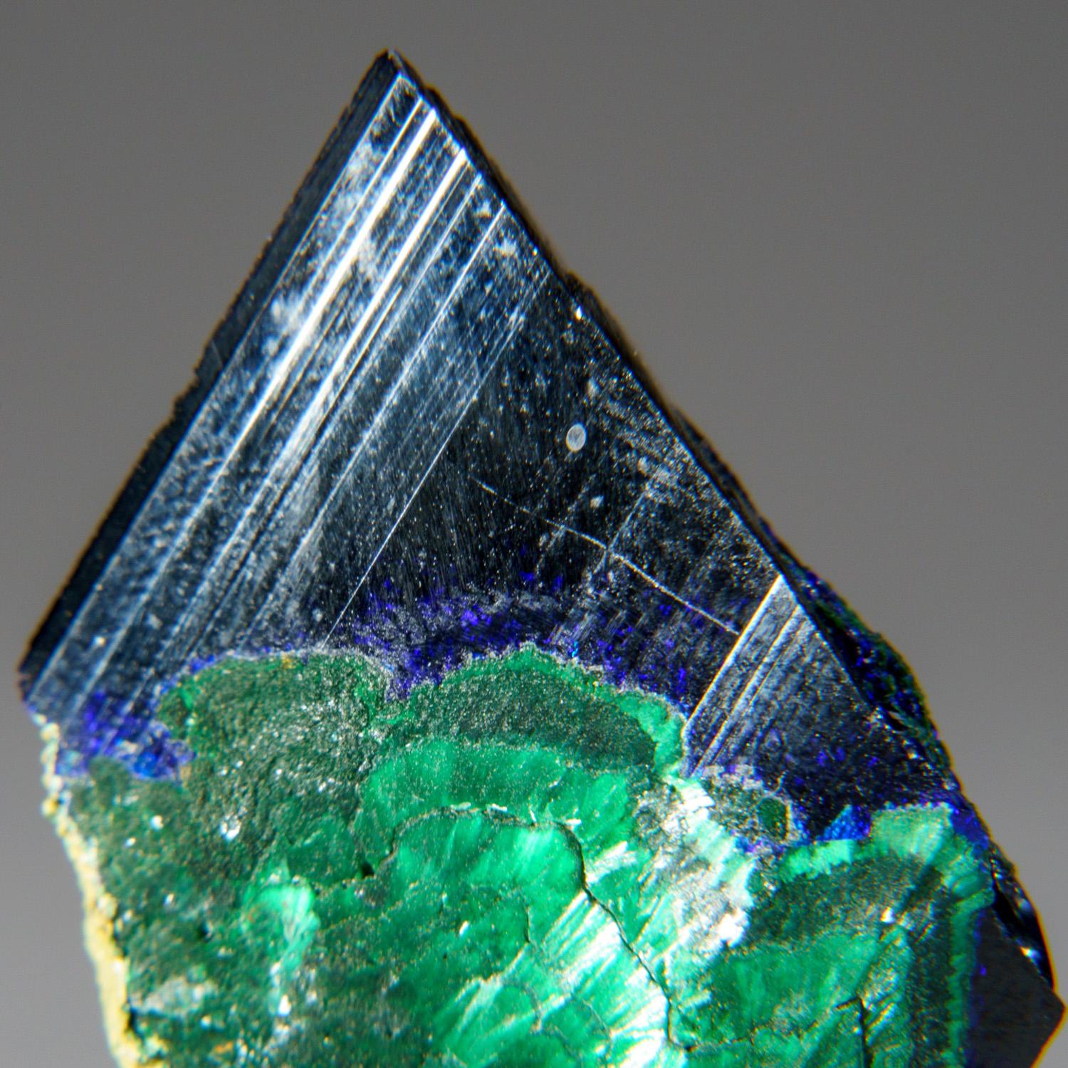 From Tsumeb Mine, Otavi-Bergland District, Oshikoto, Namibia

Large single crystal of translucent blue azurite with scattered areas that partially altered to green malachite. The azurite crystal is striated bladed form with chisel-shaped