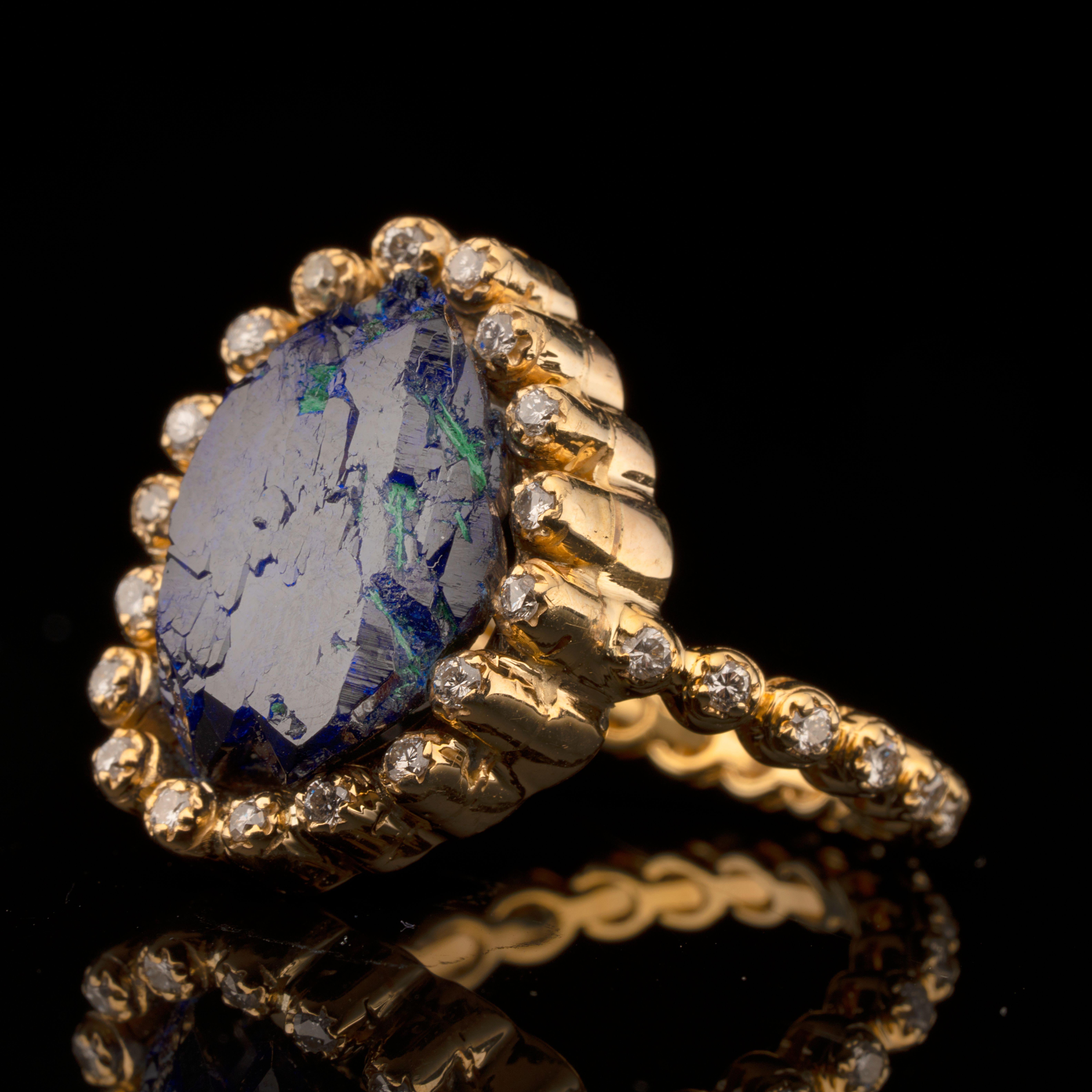 This stunning custom one of a kind ring showcases a sizable raw azurite with accents of vivid malachite in a scalloped 14 karat gold setting lined in 38 round cut diamonds around both the band and center stone for a total of approximately 0.40