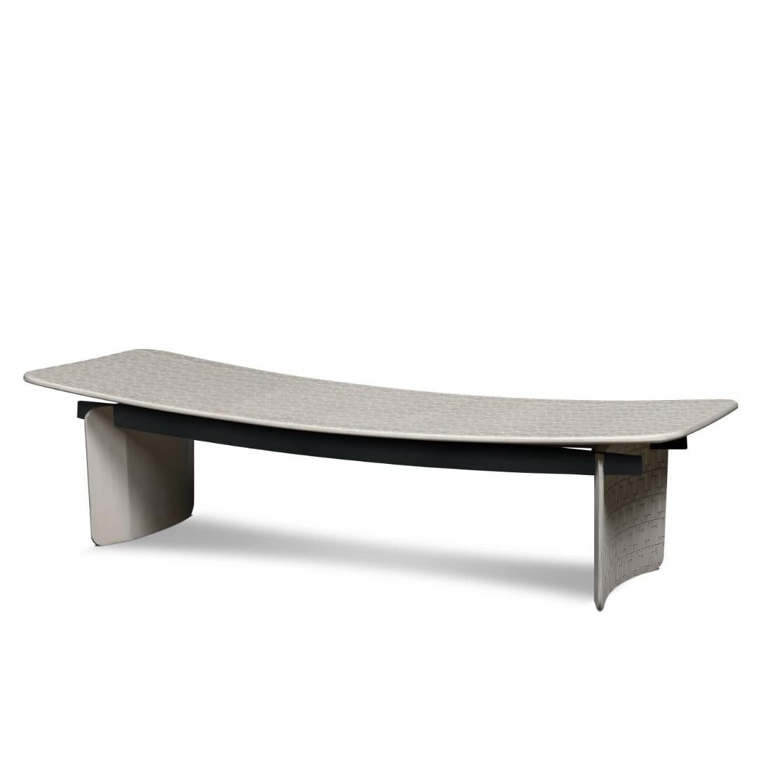 This bench showcases delicate curves and fine geometric decorations on its seat and base. Its cover rests on two metal crossbars that join the two concave legs. The final finish can be in marseille, black or metal.
 