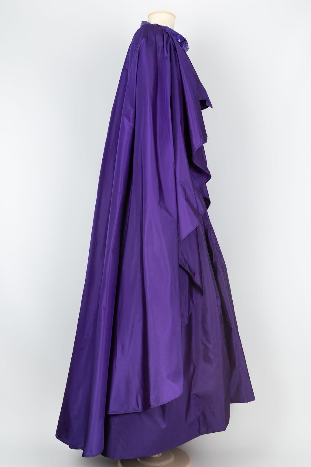 Azzaro -(Made in France) Evening dress with a taffeta cape embroidered with sequins. No label of composition or size indicated, it fits a 40FR. To note, stains present on the back of the cape.

Additional information: 
Dimensions: Dress: Chest: 40