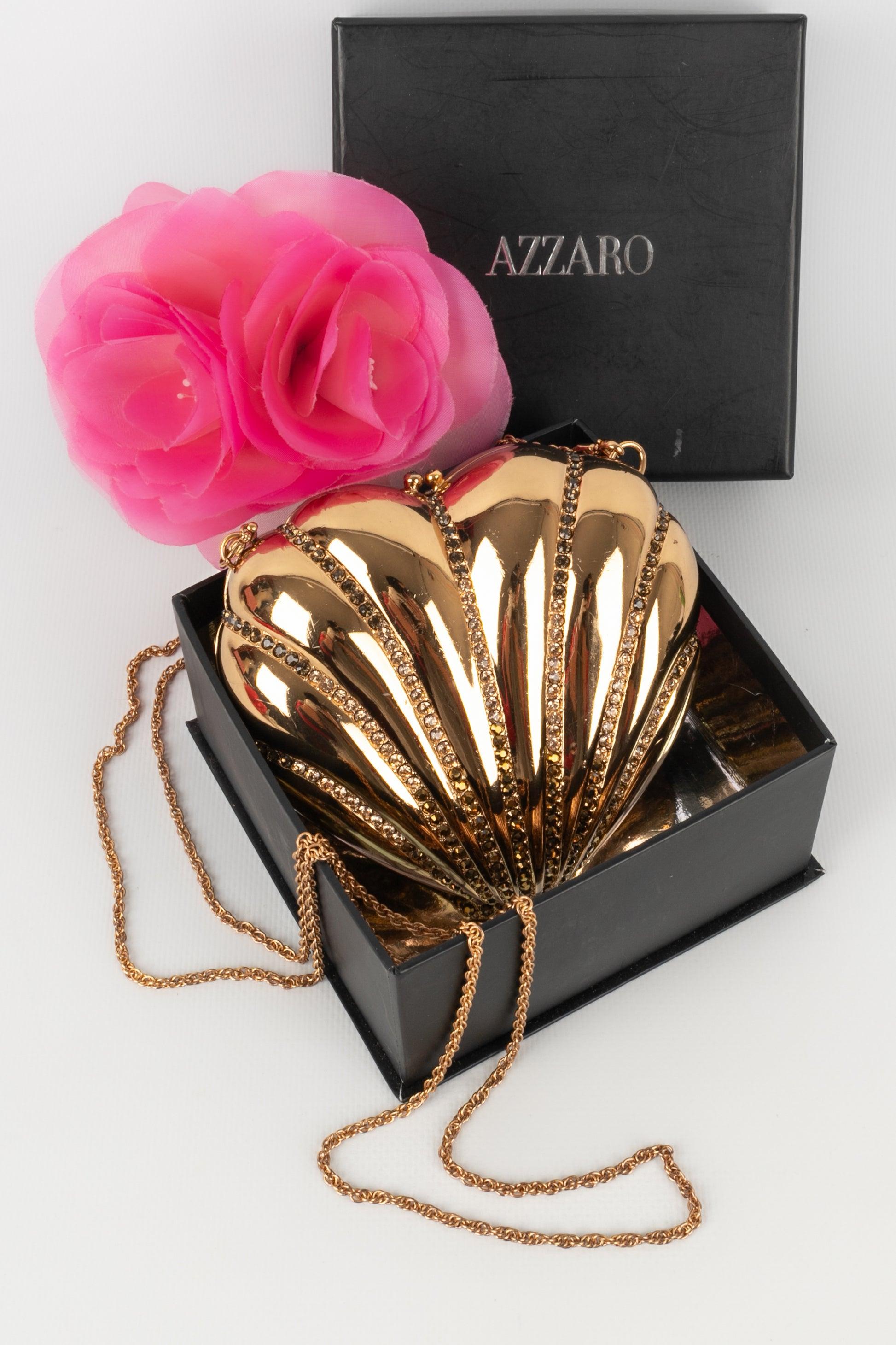 Azzaro - Minaudière in gold metal decorated with rhinestones, interior in black enameled metal. Please note, some rhinestones are missing.

Additional information: 
Condition: Good condition
Dimensions: Height: 14 cm - Width: 15 cm - Depth: 2 cm -