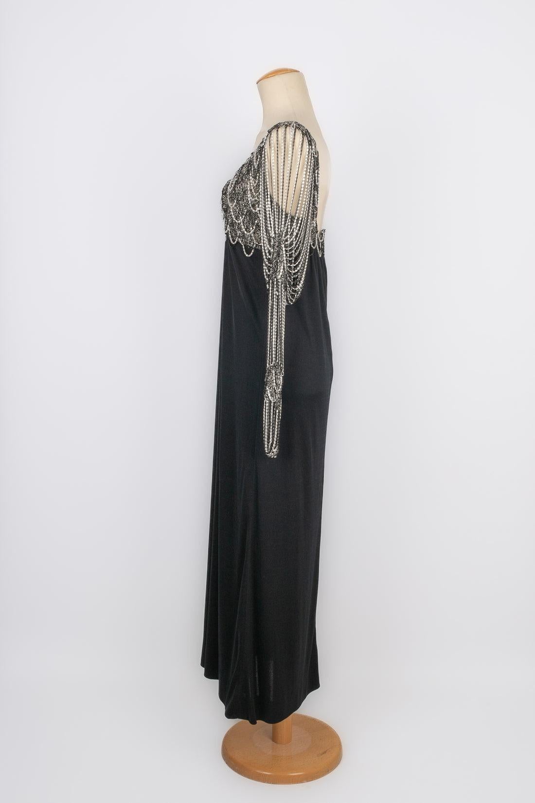 Azzaro - (Made in France) Long dress in black jersey, lurex and black and white chain. Composition and size labels missing, it fits a 36FR.

Additional information:
Condition: Very good condition
Dimensions: Chest: 41 cm - Sleeve length: