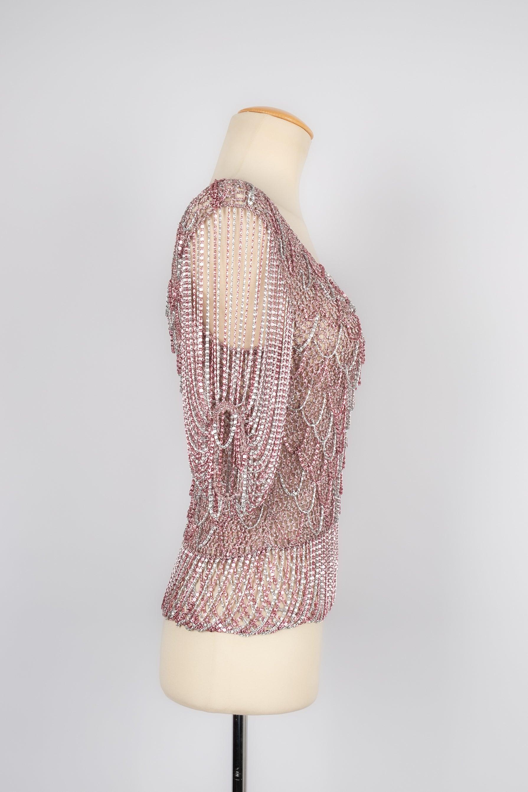 Azzaro - (Made in France) 1970's silvery and pink lurex top ornamented with a chain. No composition nor size label, it fits a 36FR.

Additional information:
Condition: Very good condition
Dimensions: Shoulder width: 40 cm - Chest: 36 cm - Waist: 29
