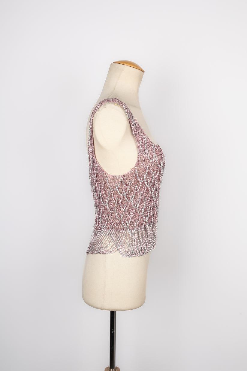 Azzaro - (Made in France) Silvery and pink lurex top ornamented with chains, top from the 1970s. No size nor composition label, it fits a 34FR/36FR.

Additional information:
Condition: Very good condition
Dimensions: Chest: 36 cm - Length: 52