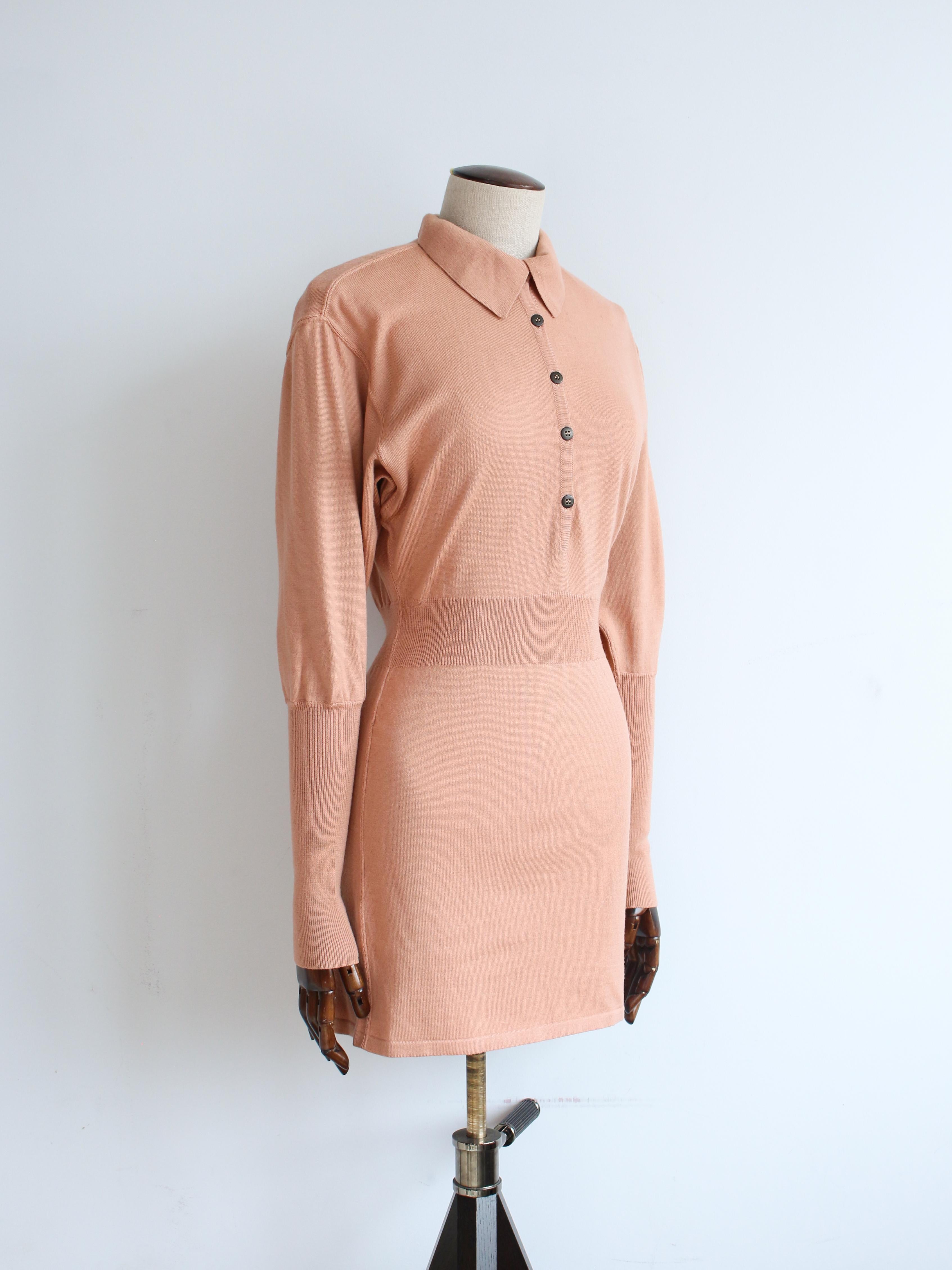 Abito in maglia Alaïa c.1985-89 in lana pesca/salmone con bottoni sul davanti, vita aderente e spalle padellate.

Contrassegnato dalla taglia S.

In buone condizioni.

