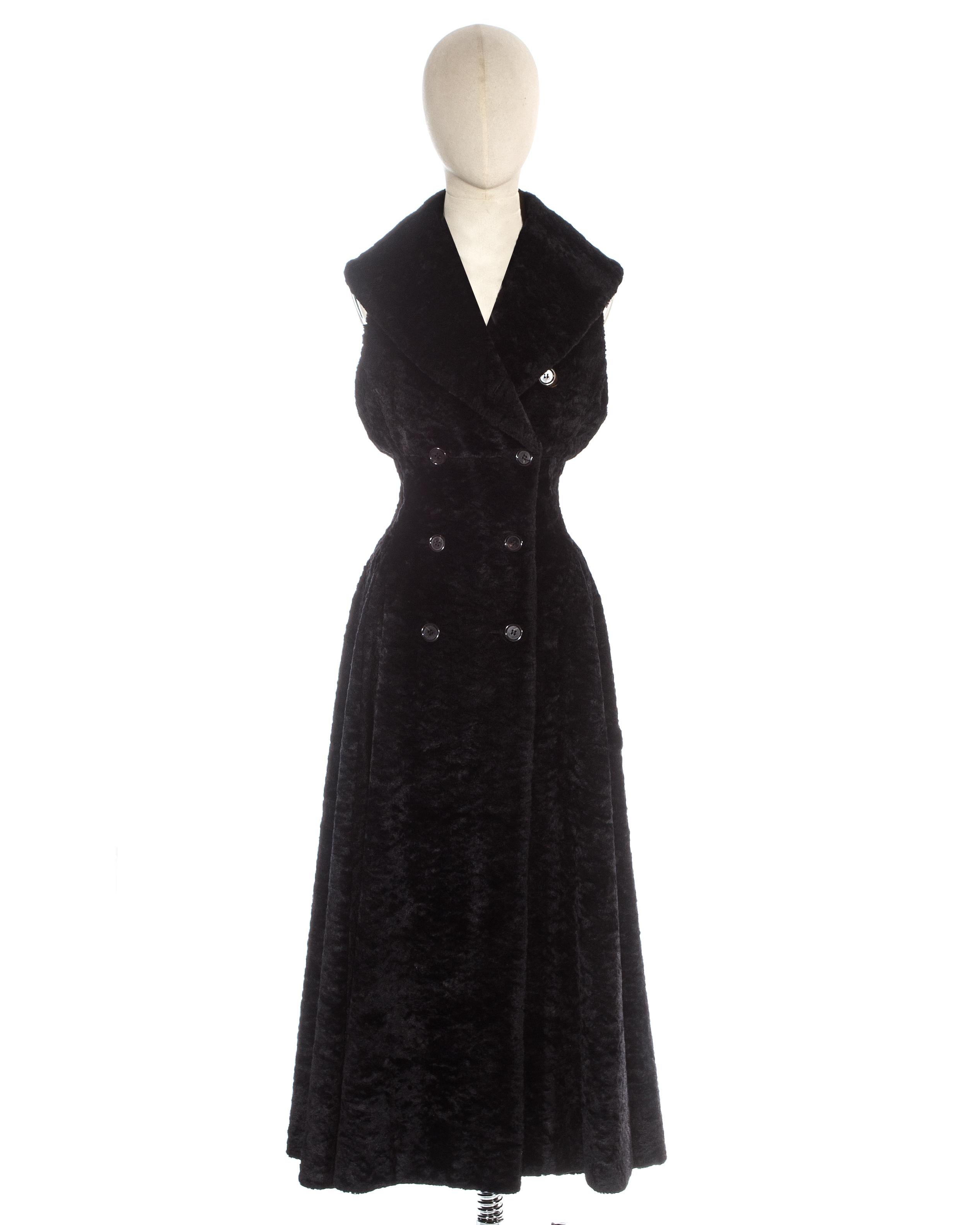 Azzedine Alaia; black chenille sleeveless double breasted coat dress with silk lining, large shawl lapel, full pleated skirt, cinched waist and 2 hidden side pockets. 

Fall-Winter 1992

Measurements:

Shoulder to shoulder 12”
Waist 26”
Bust