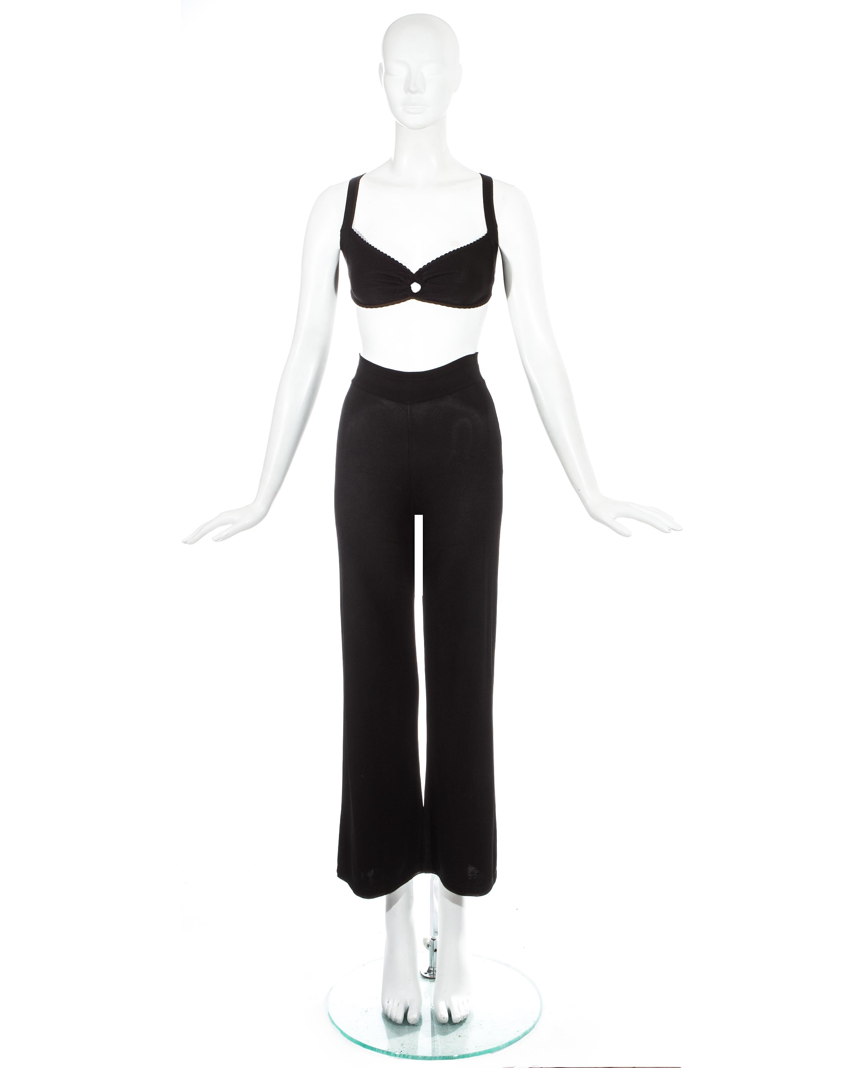 Azzedine Alaia; black knitted 2-piece pant suit. Fitted bra with circular cut-out and bondage straps. High waisted wide leg pants with elastic waistband. 

Spring-Summer 1993