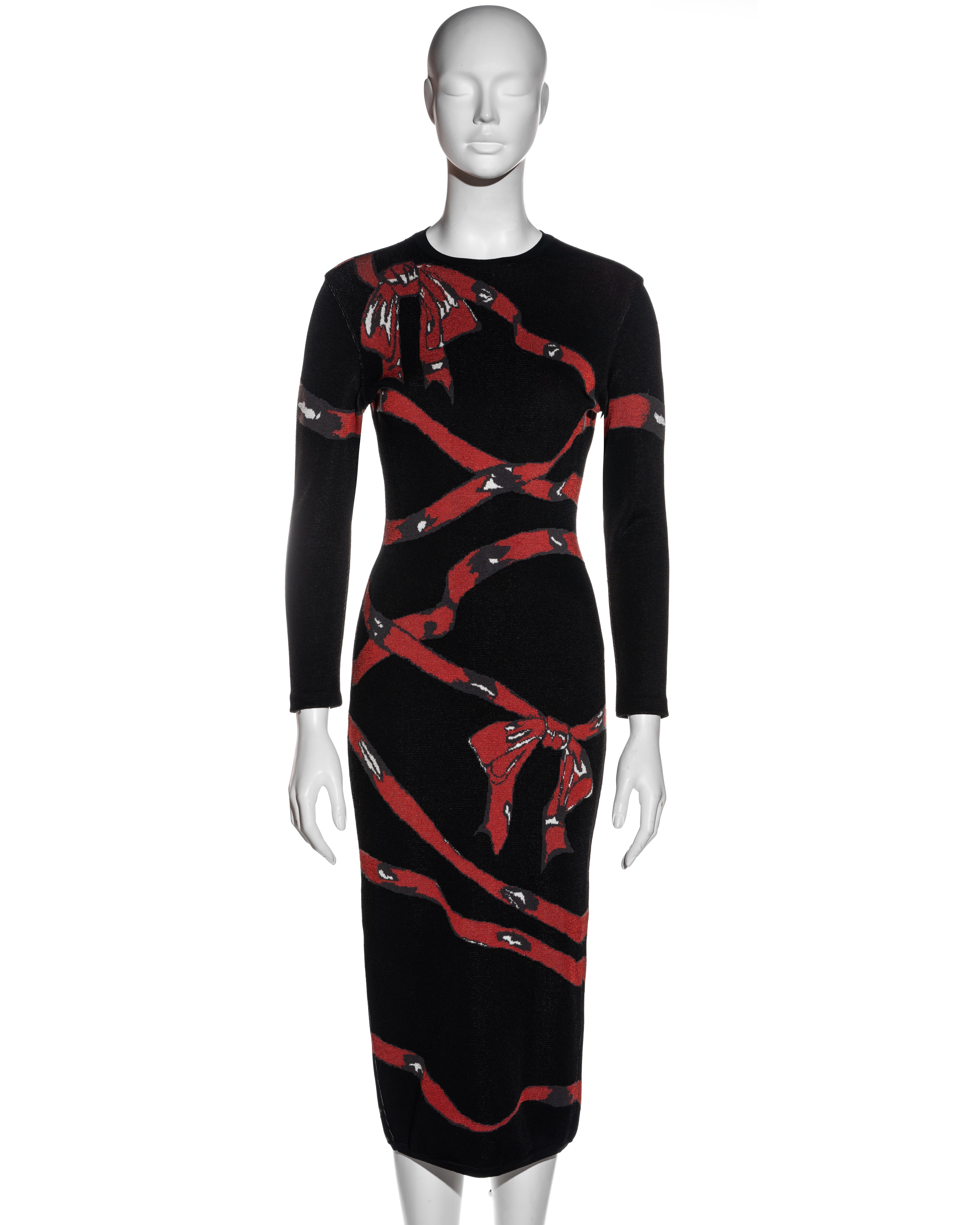 ▪ Azzedine Alaia black rayon knitted bodycon dress
▪ Red ribbon and bow graphic 
▪ Centre back leg slit with concealed zipper 
▪ Long sleeves 
▪ Calf length 
▪ Size Medium
▪ Fall-Winter 1992