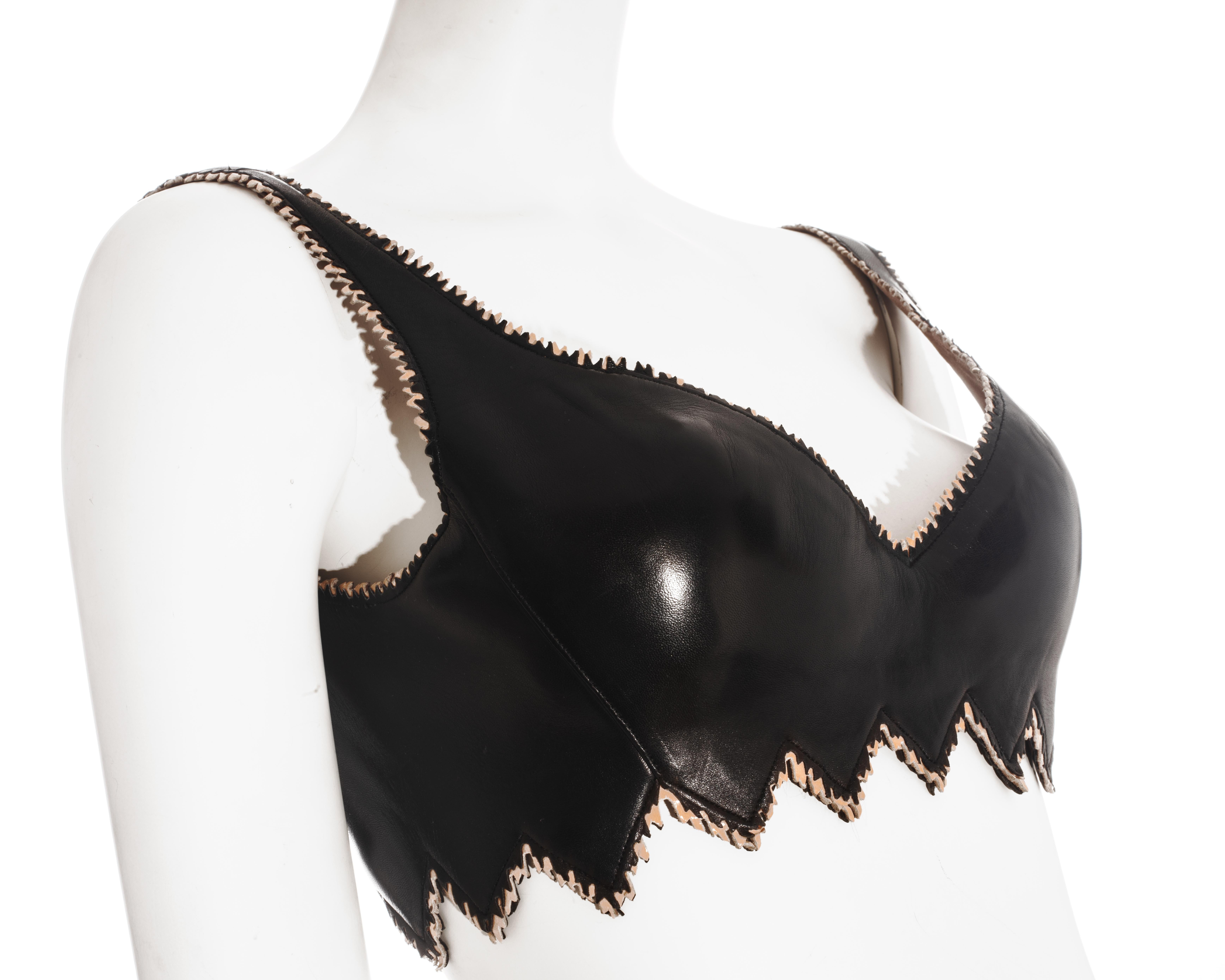 Azzedine Alaia black leather corseted bra with laser-cut jagged edge, built-in padded bra, adjustable size with lace up fastening and side zip closure. 

Fall-Winter 1994
