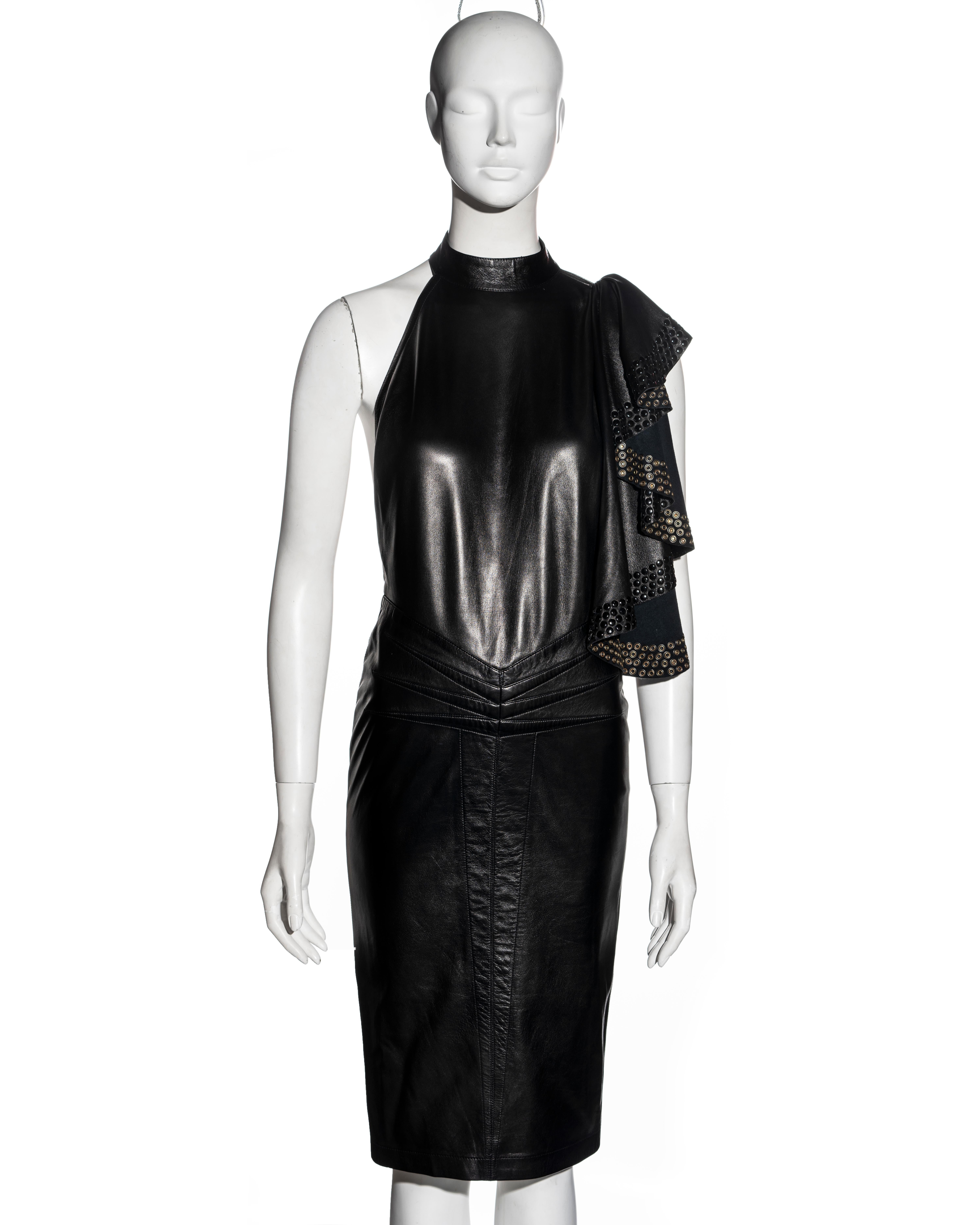 ▪ Important and early Azzedine Alaia black leather dress
▪ Museum grade
▪ Draped panel embellished with metal eyelets
▪ Choker neck 
▪ One strap connecting the shoulder to the waist 
▪ Corset-style lace fastening at the center-back waist
▪ Six darts