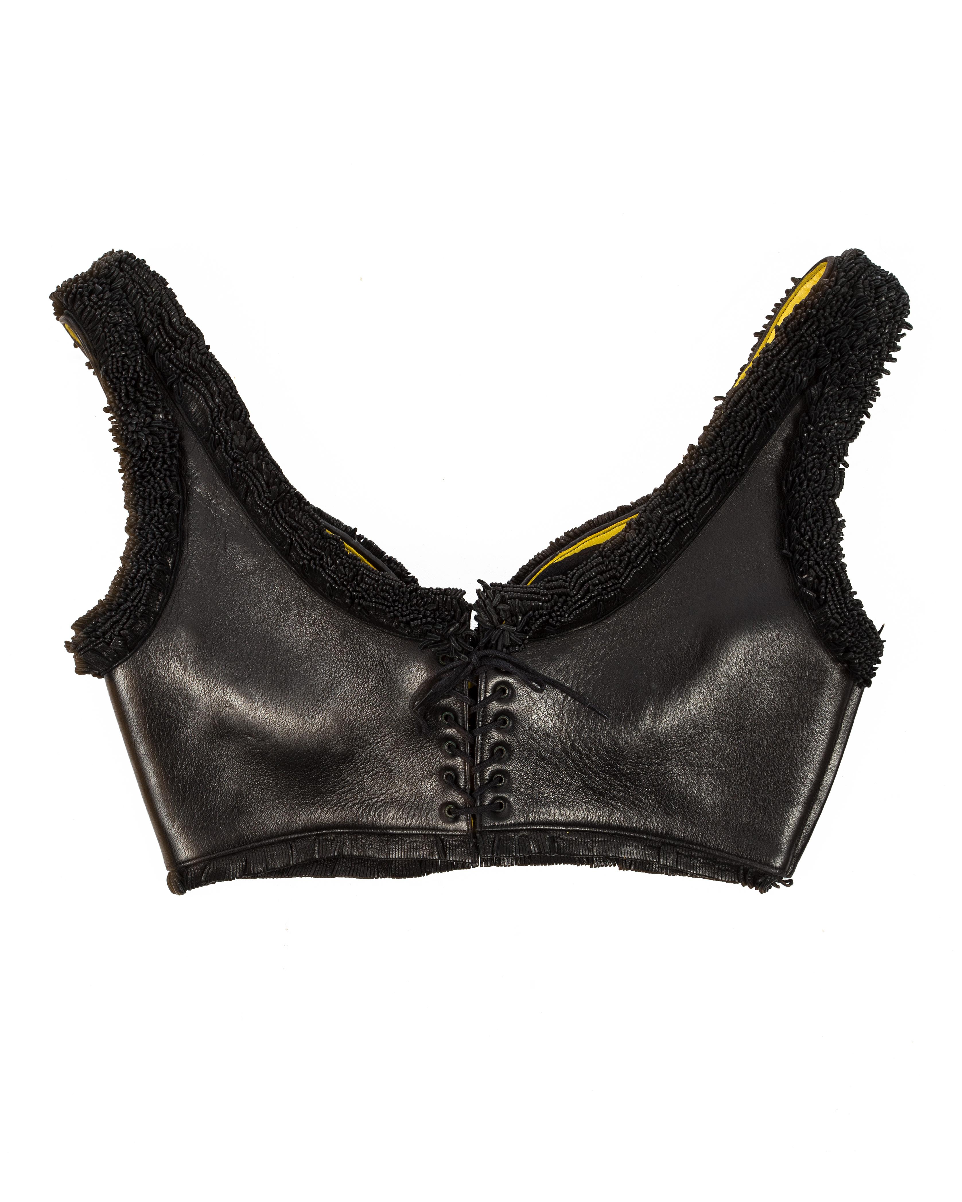 Azzedine Alaia; Black leather fringed bra with yellow leather backing, lace up fastening, built in padded bra and side zip closure

ca. 1994