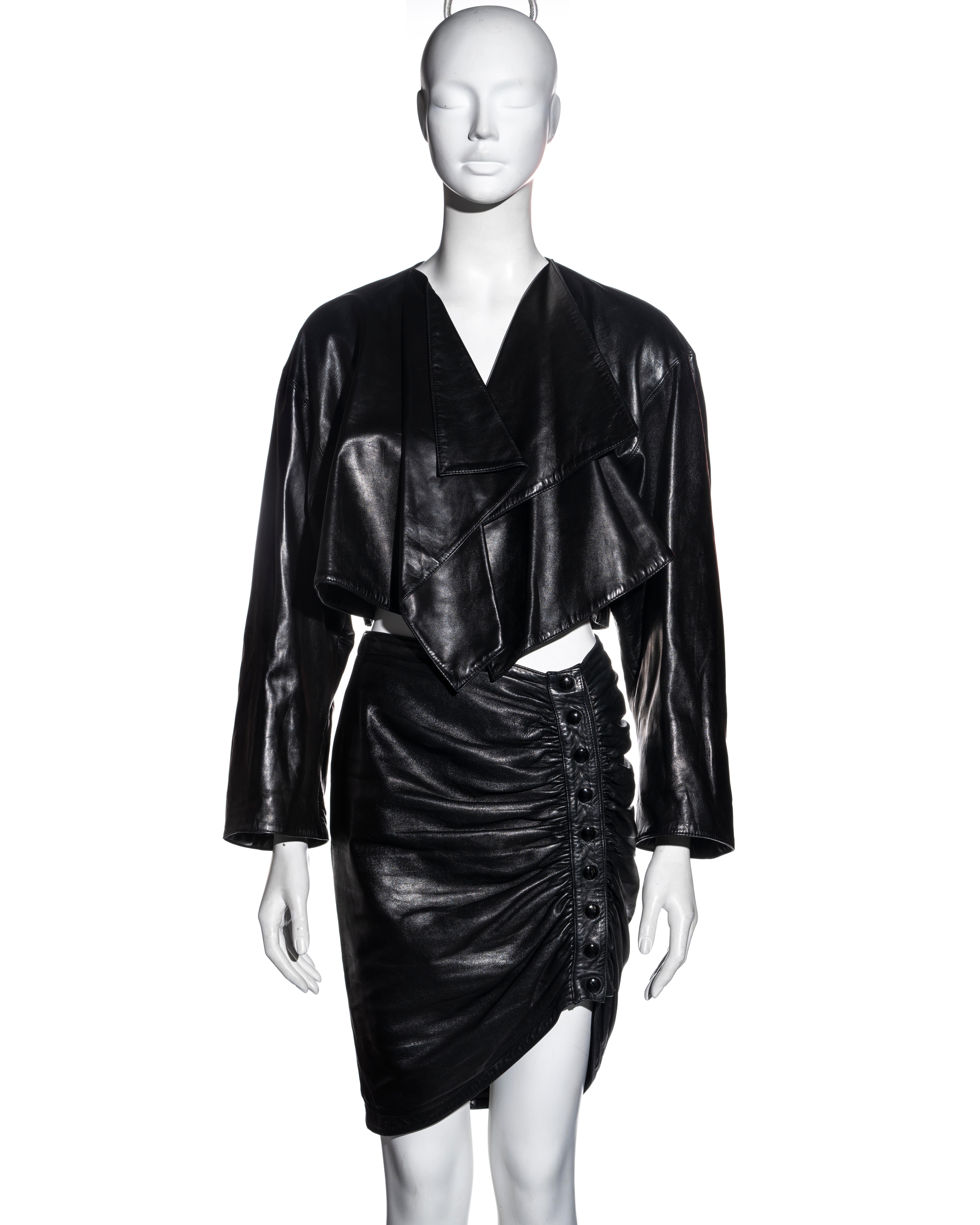 ▪ Rare Azzedine Alaia black leather jacket and skirt set
▪ Wide-cut bolero jacket with open front and draped lapels 
▪ Fitted pencil skirt with asymmetric hemline
▪ Ruched detail at the front opening with snap-button closures 
▪ FR 40 - UK 12 - US