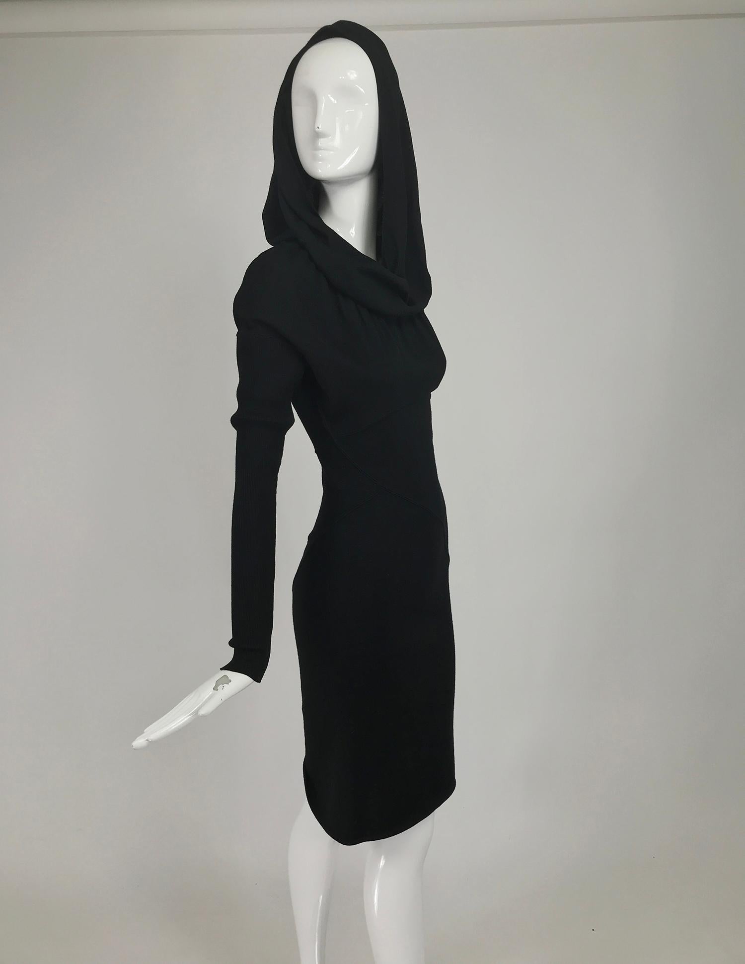 Azzedine Alaïa 1980s black wool knit hooded body con mini dress. This amazing version of the iconic dress with hood has is done in black wool. The bodice is flat knit the extra long sleeves are ribbed knit, with dropped shoulder line. A flat curved