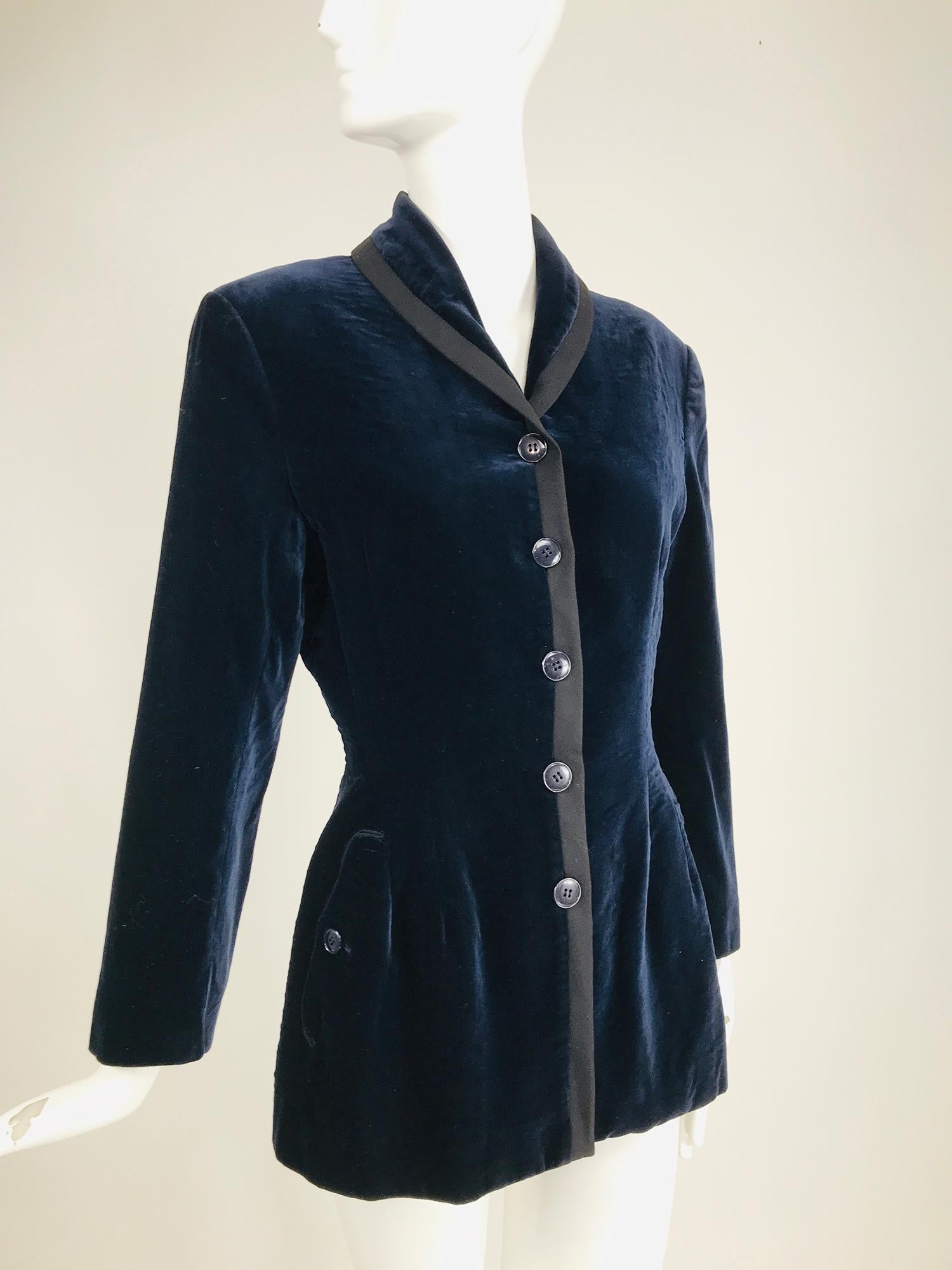  Azzedine Alaïa blue velvet fitted frock style jacket from the 1980s. A beautiful jacket that references the 18th century men's style. Single breasted jacket in dark blue velvet, with a shawl collar, it buttons up high, with front facings trimmed