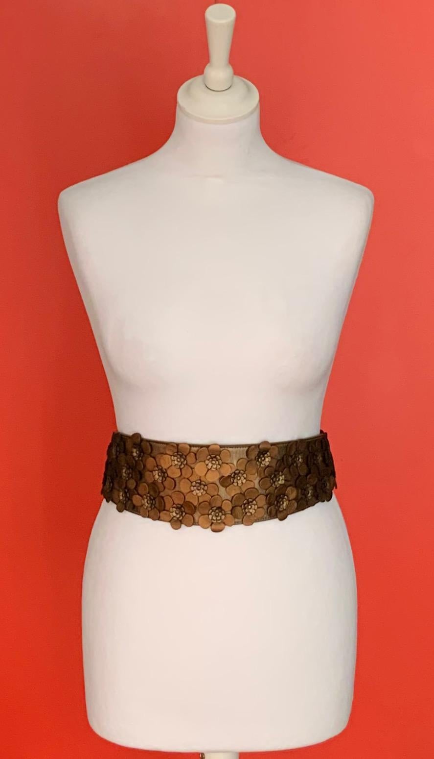 Very elegant belt of the house Azzedine Alaïa crafted in a bronze color leather garnished with a multitude of flowers in the same material and tones.

Material: leather
Color: bronze
Hardware: metal
Size: 70
Measurements: Length: 81,5 cms - approx.