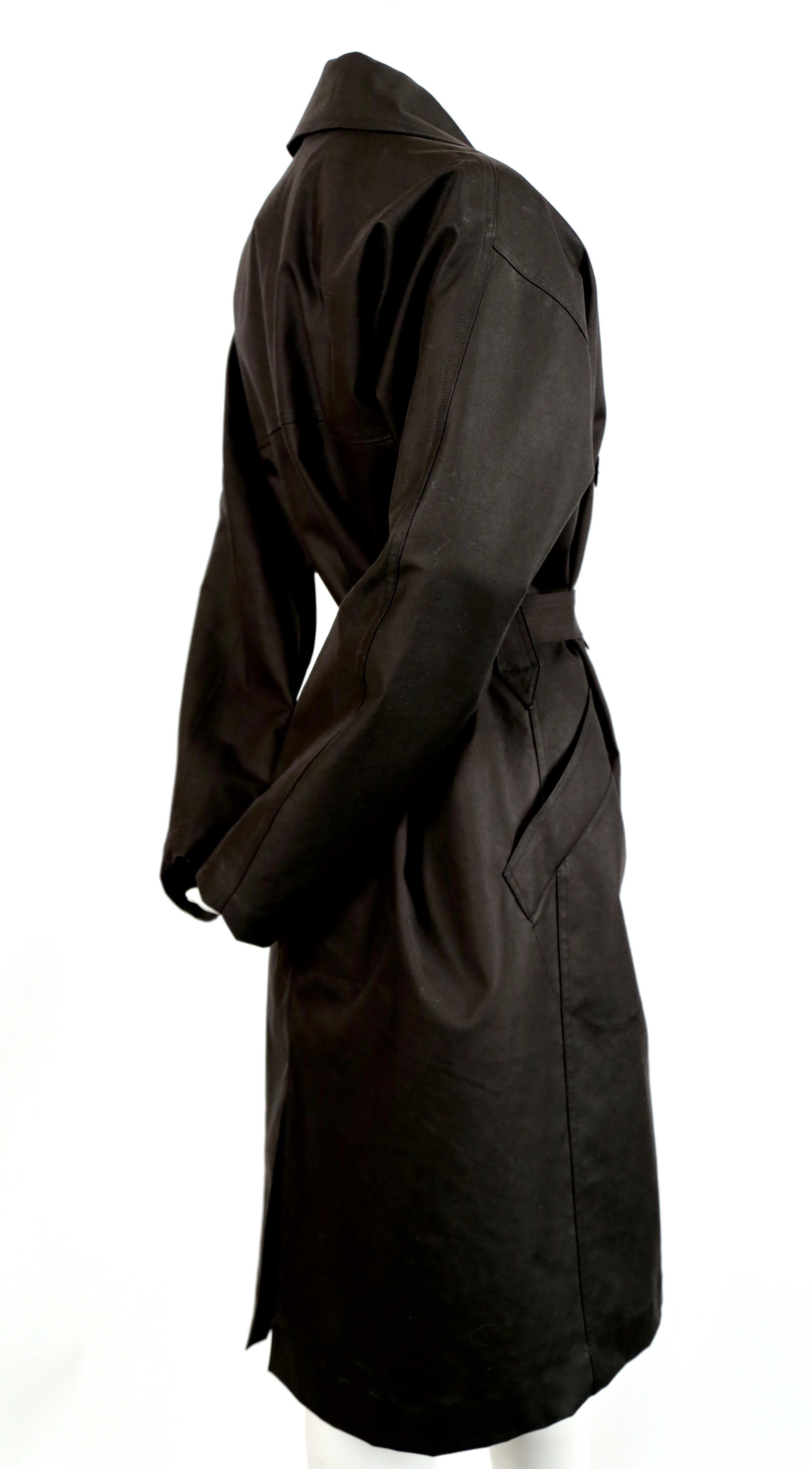 Classic soft black cotton trench designed by Azzedine Alaia. French size 40. Coat has a loose cut with fitted belt. Best fits a US 2-6. Photographed (unclipped) on a size 2 mannequin who measuring 32