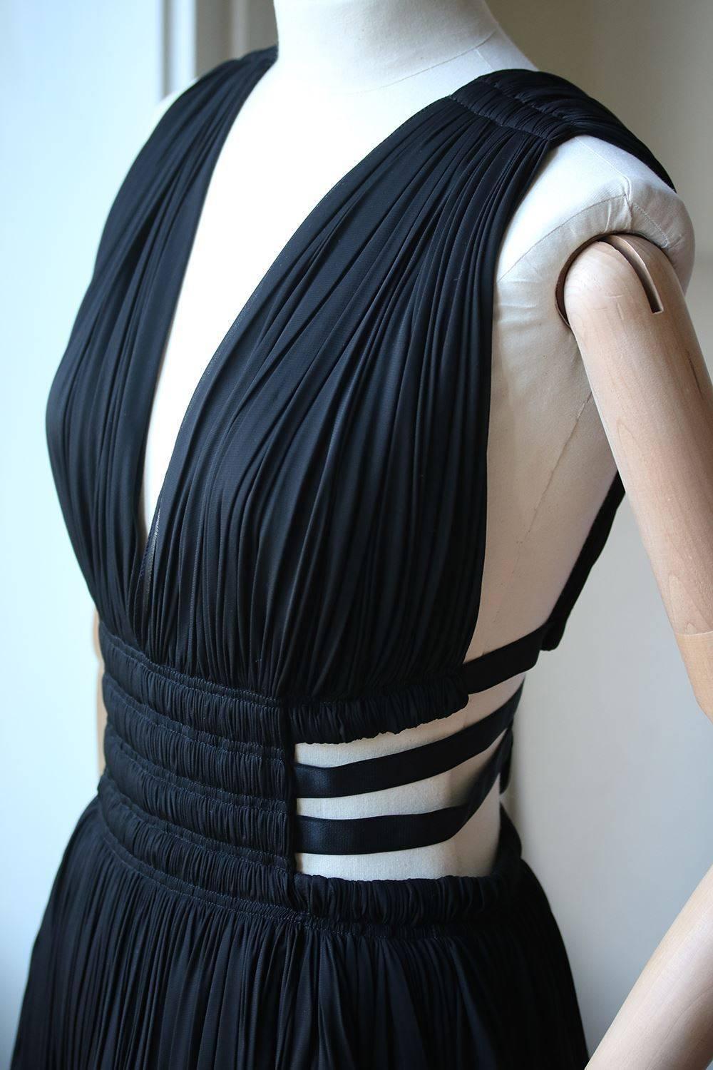 Black semi sheer ruched dress with cutout sides and elastic bands from Azzedine Alaia. Dress has a hidden bodysuit with zip/snap closure below skirt for modesty. Made in Italy. 

Size: FR 38 (UK 10, US 6, IT 42)

Condition: Worn once. Slight tear in