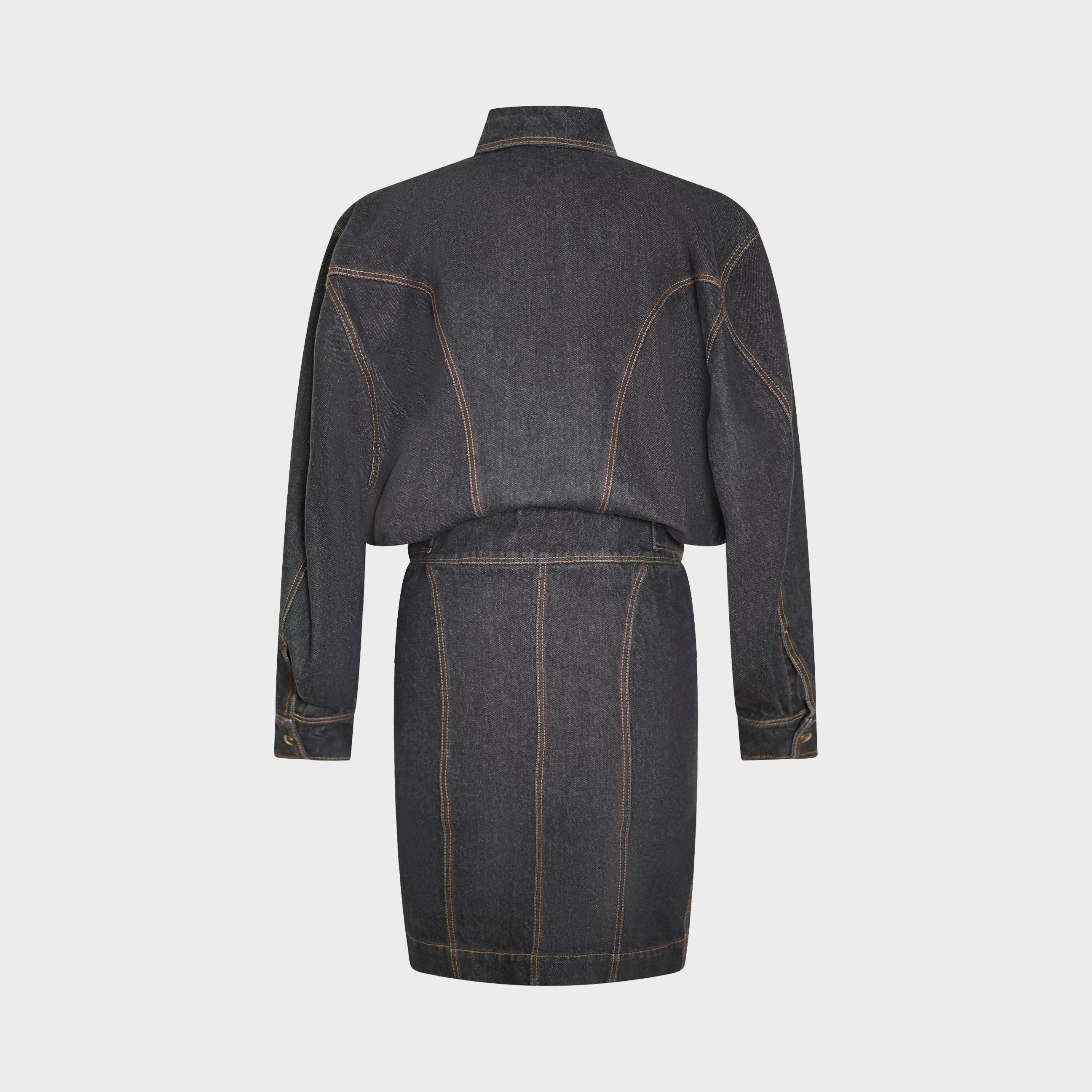 Issue du défilé emblématique printemps/été 1986 d'Azzedine Alaïa (Look 9), cette robe en denim foncé illustre la précision architecturale et la maîtrise de la coupe du créateur. Entièrement réalisé en denim de coton structuré, il présente des