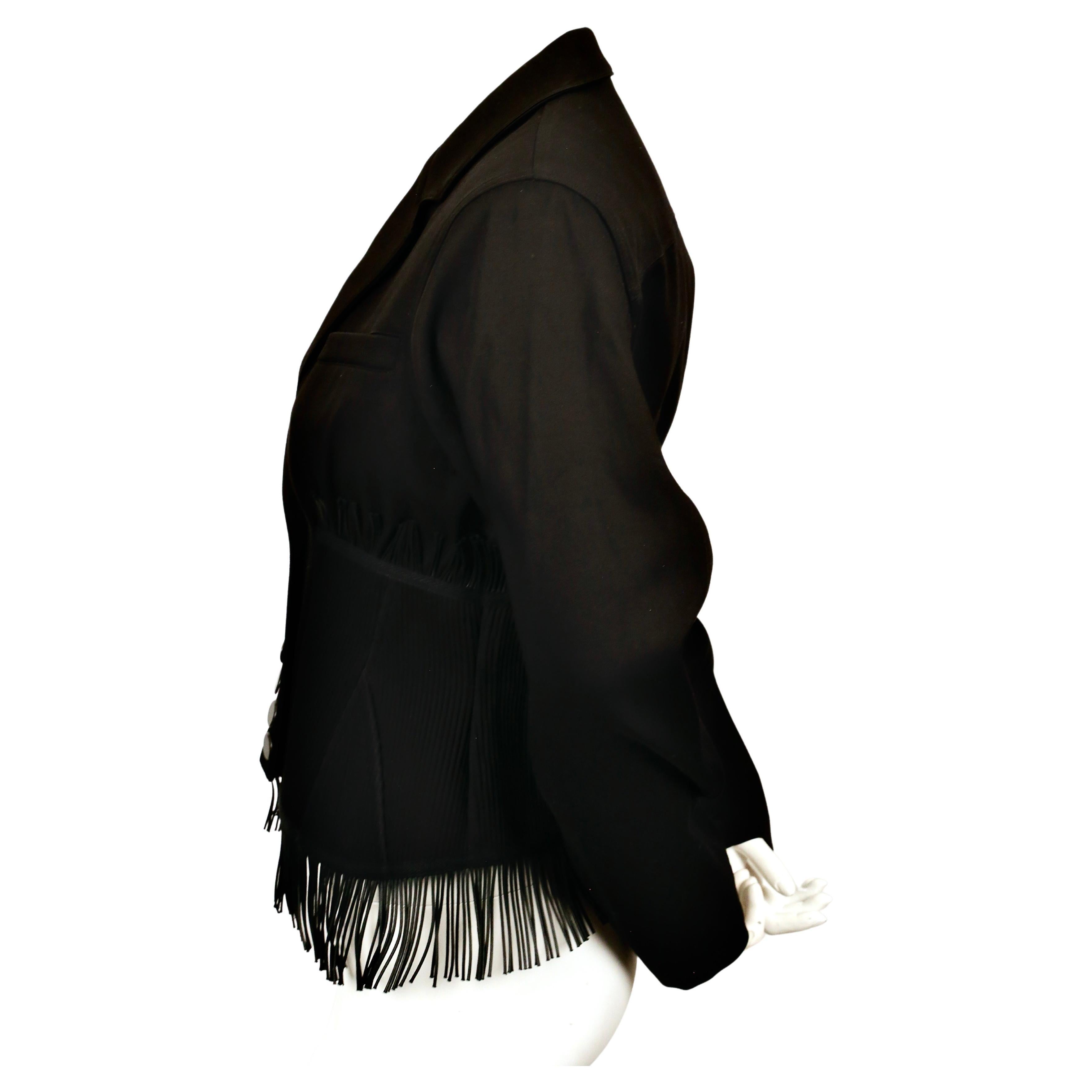 Veste corset en gabardine de coton noir de jais avec empiècements surpiqués, armatures et franges, signée Azzedine Alaia. Cette veste est une réédition de la veste du printemps 1998. Taille française 38 (taille fine). Mesures approximatives : épaule