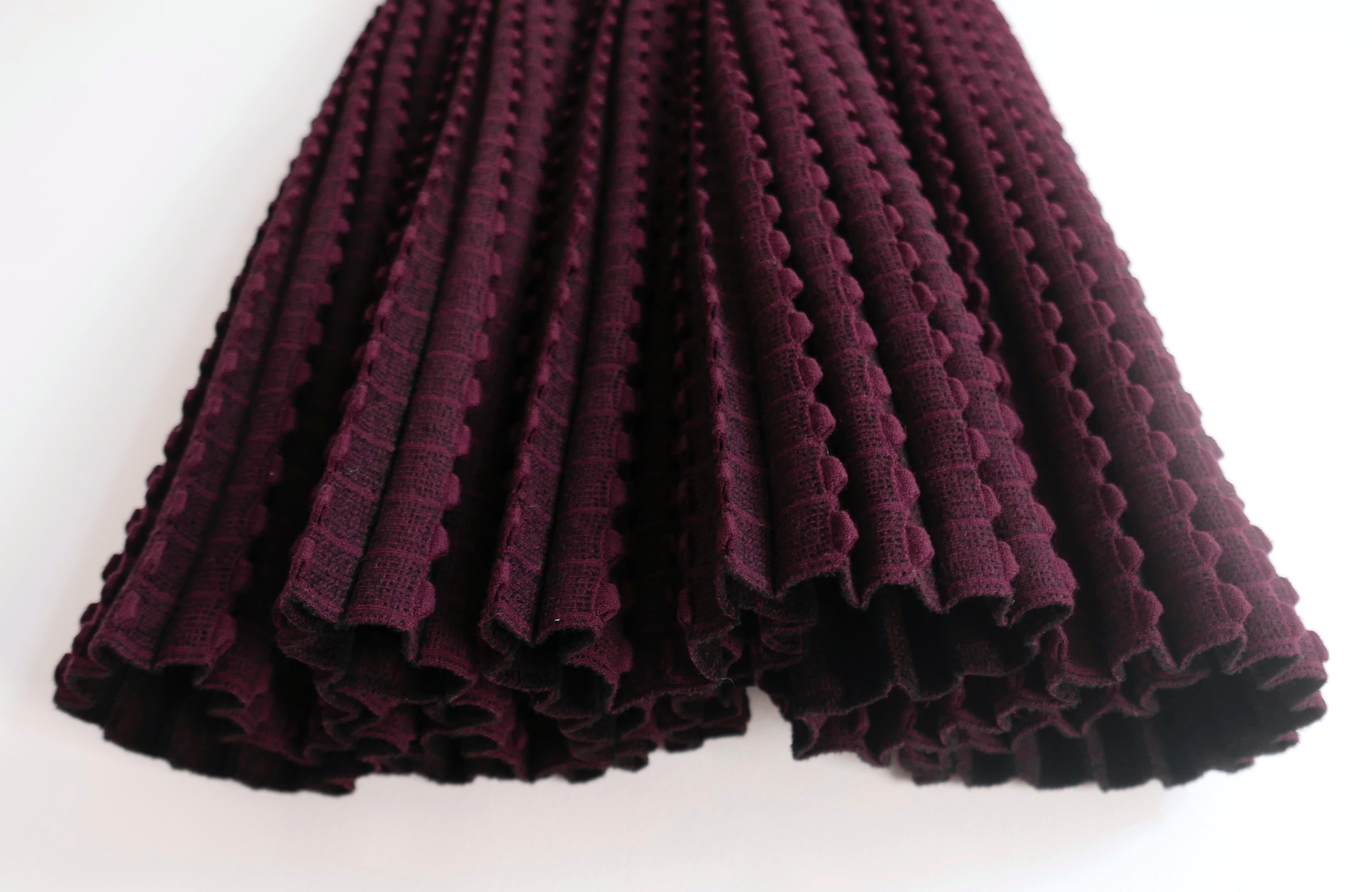 Stunning archival Azzedine Alaïa textured wool skater dress from the Fall 2010 collection. Unworn. Made from super heavy dark plum coloured multi textured wool mix, it has a classic 2000s Alaïa silhouette with fitted bodice, ribbed dropped waist and