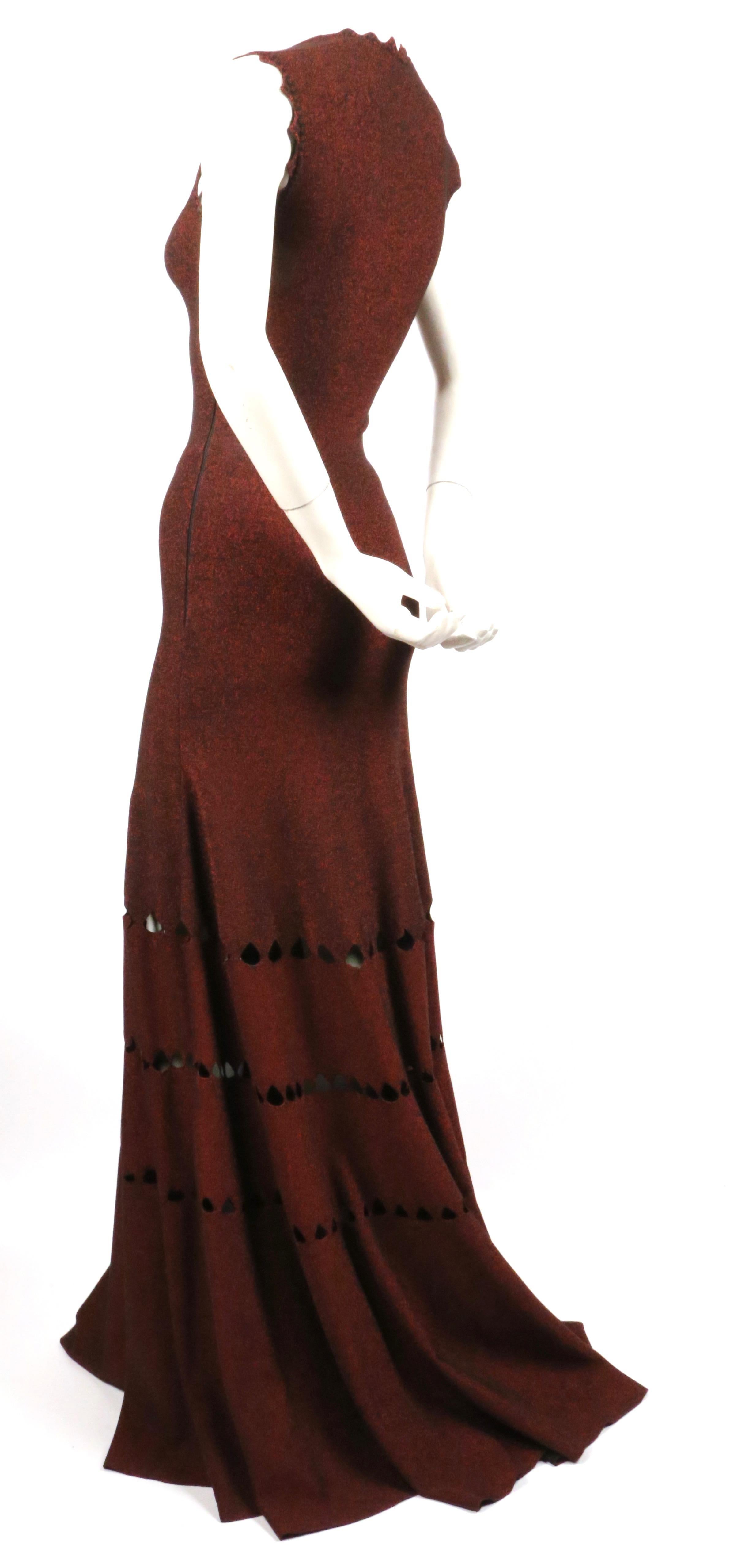 Dramatic, floor-length gown with geometric cut-outs and scalloped hemline designed by Azzedine Alaia. Color is an unusual, metallic burgundy-copper tone. Labeled a French size 36. Fits a US 0-2. Approximate measurements (unstretched): bust 27