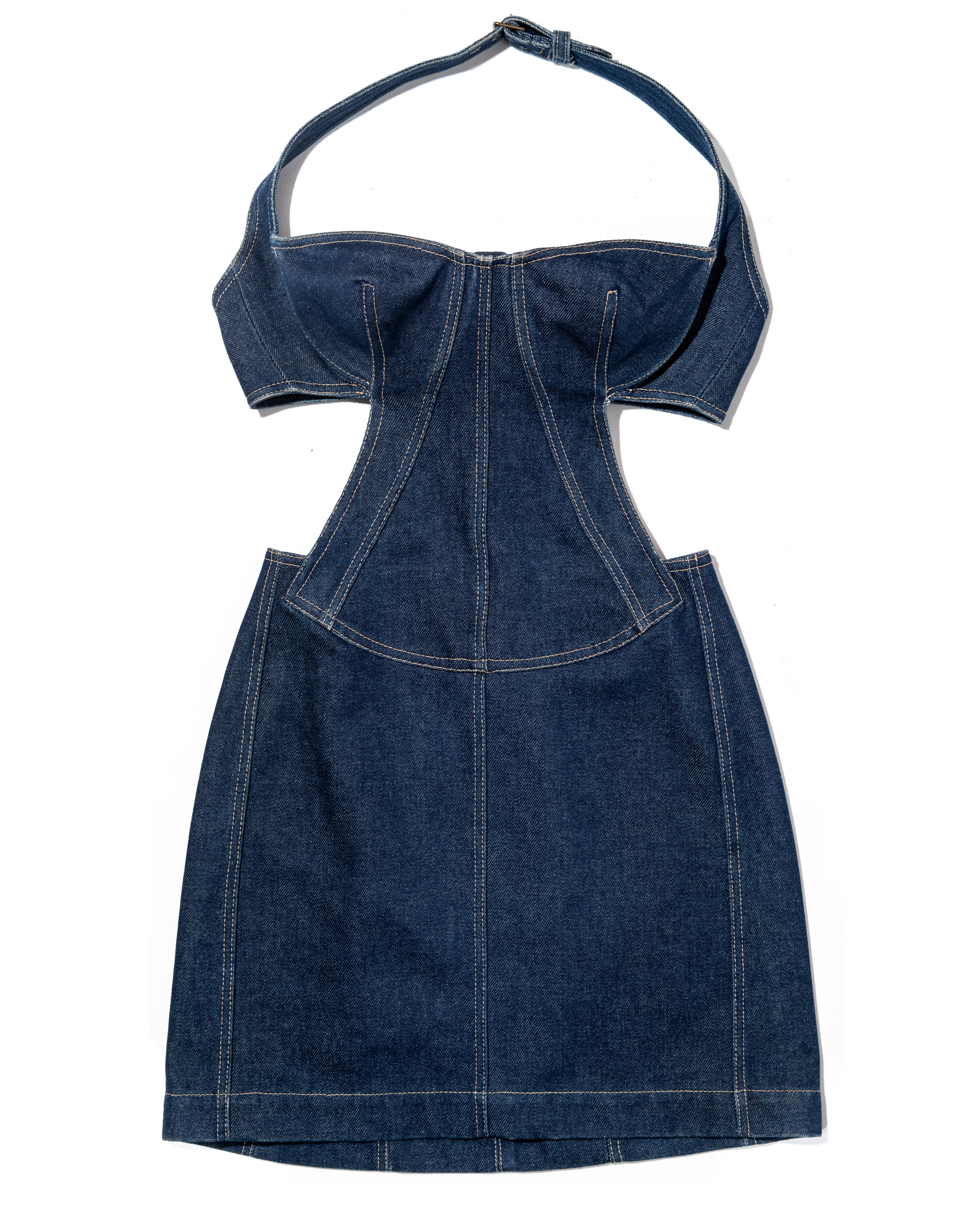 ▪ Azzedine Alaia indigoblaues Denim-Minikleid mit Neckholder
▪ Bustier mit Bügel-BH
▪ Durchgehend flache Kappnähte in cremefarbenem Kontraststich 
▪ Offene Seiten und Rücken 
▪ Korsettschnürung in der hinteren Mitte 
▪ Metallschnallenverschlüsse im