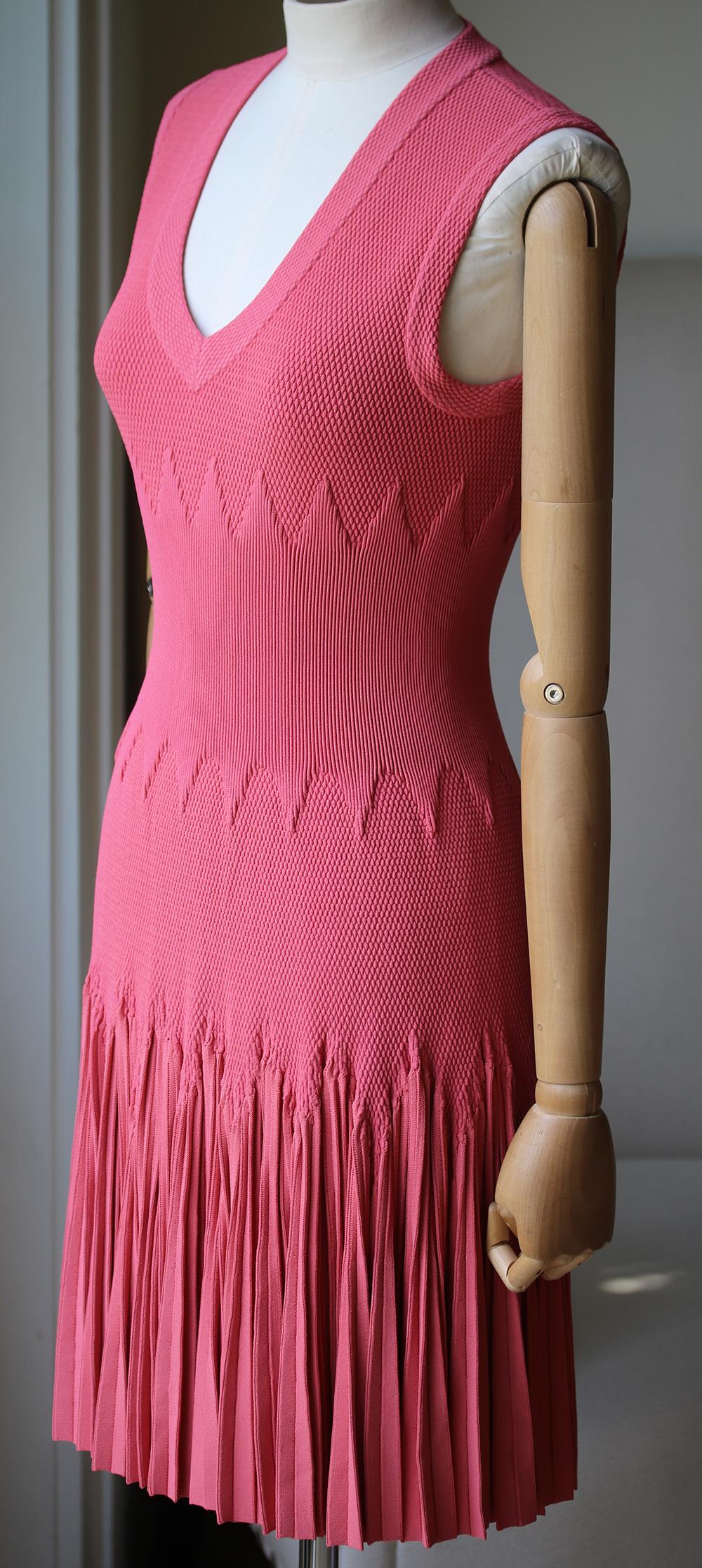 A coral pink skater cotton blend fitted dress by Azzedine Alaia . Concealed zip closure in the back. Flattering shape, extra synched in ruched waist perfect for flattering the hips and bust, pleated detail on the skirt of the dress. There is some