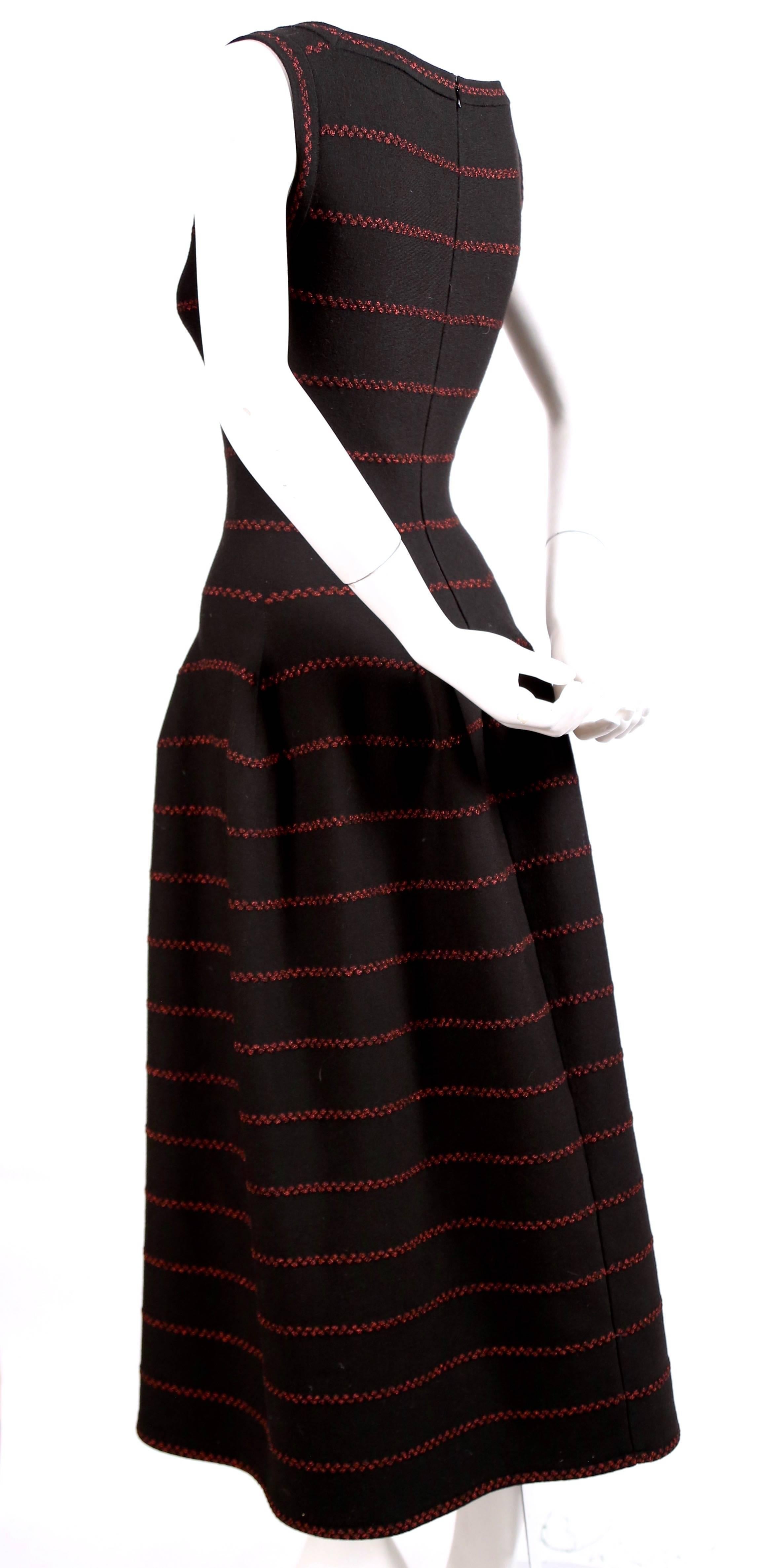 Long black knit dress with red lurex detail designed by Azzedine Alaia. Square boat neckline. Beautiful seaming creates the full skit. French size 40 which fits a US 4-6. Approximate measurements (unstretched): shoulder 14