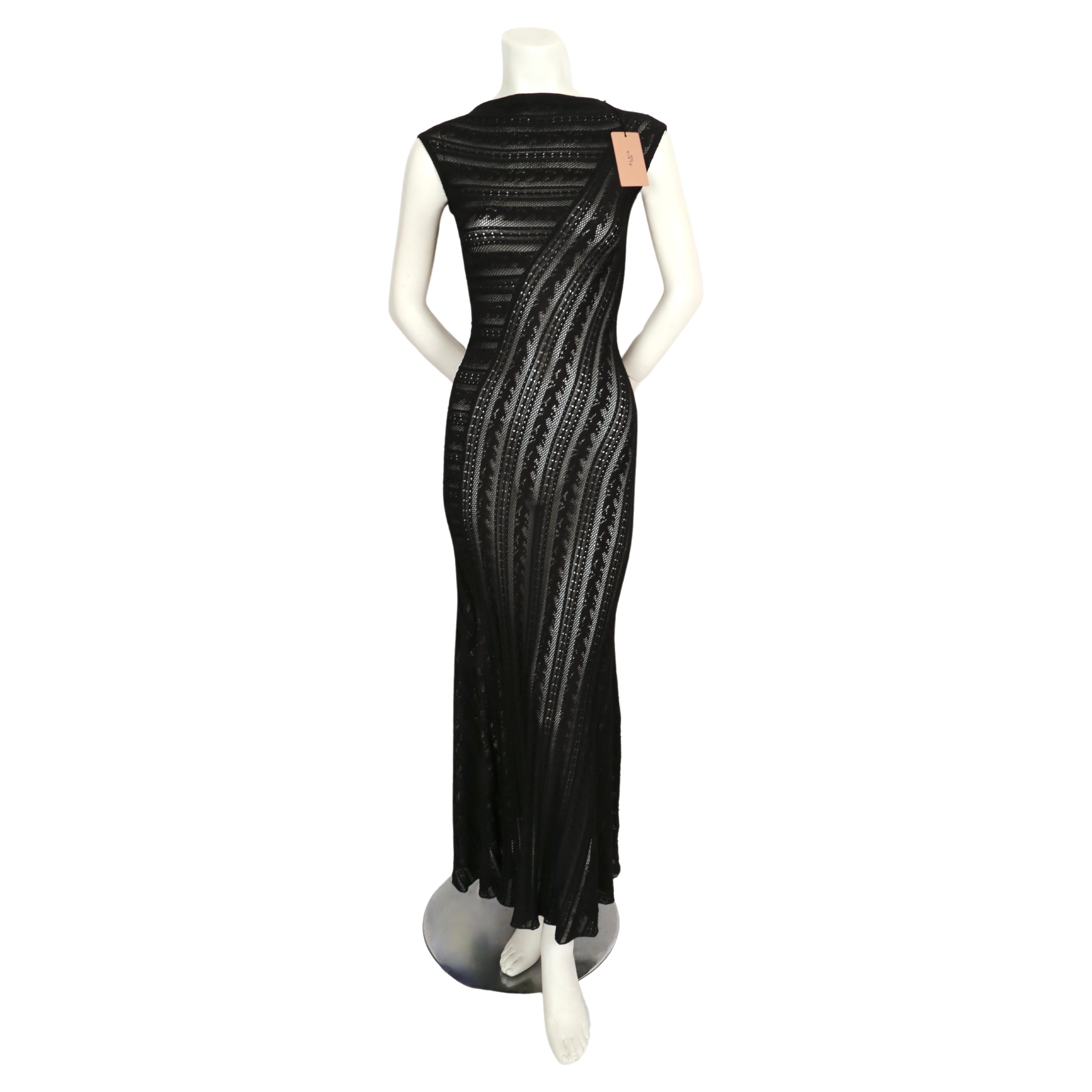 Long black lace knit dress designed by Azzedine Alaia. The high neckline and beautiful seaming creates a very flattering fit. French size 38 which best fits a US 2-6. Approximate measurements (unstretched): shoulder 14