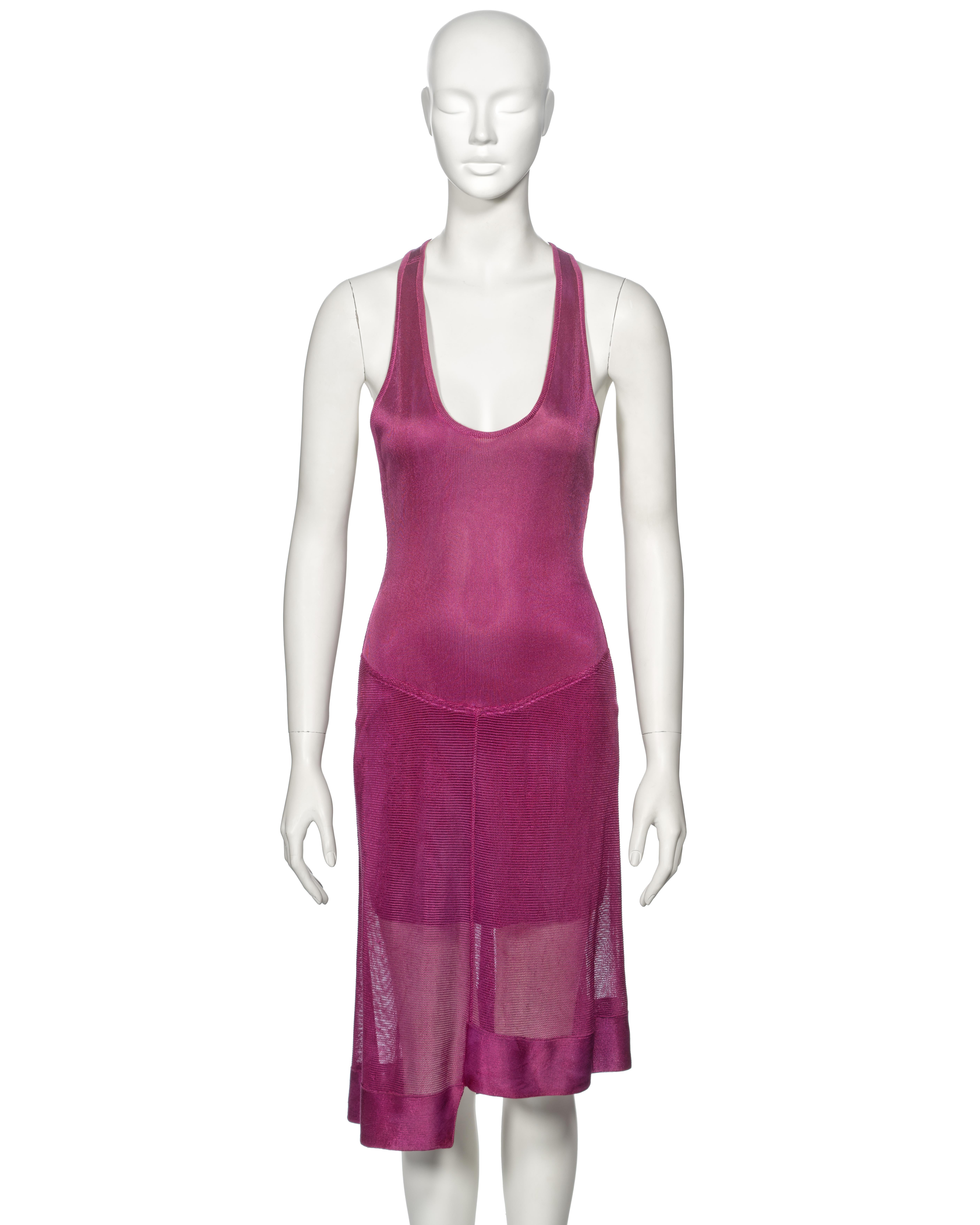 ▪ Archival Azzedine Alaia Cocktail Dress
▪ Spring-Summer 1986
▪ Constructed from magenta acetate knit fabric 
▪ Body conscious fit 
▪ Semi-sheer knee-length skirt with irregular hemline
▪ Built-in mini skirt 
▪ Open back 
▪ Criss-cross shoulder