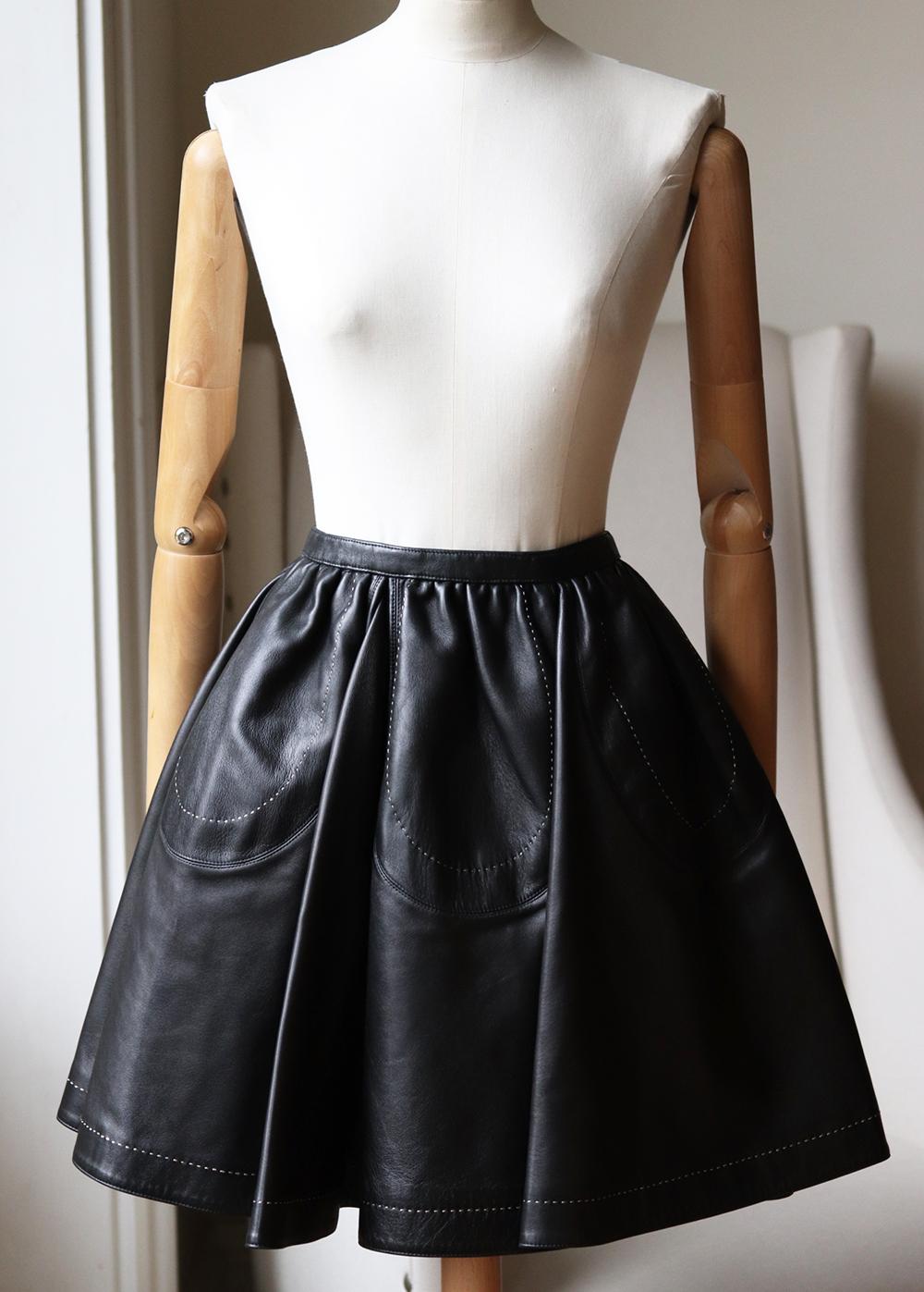 This beautiful Alaïa skirt has been engineered for the perfect fit, it is made from leather and traced with beige thread edging along the scalloped design and hem. 
Black leather.
Concealed hook and zip fastening at side.
100% Leather (Lamb);