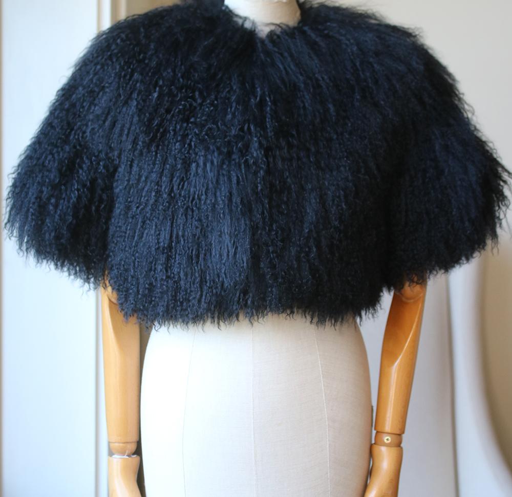 Azzedine Alaïa would oversee every part of the design process at his atelier in France. This cape is meticulously crafted from swathes of soft and curly shearling and lined in smooth satin. Black shearling. Concealed hook fastening at front. 100%