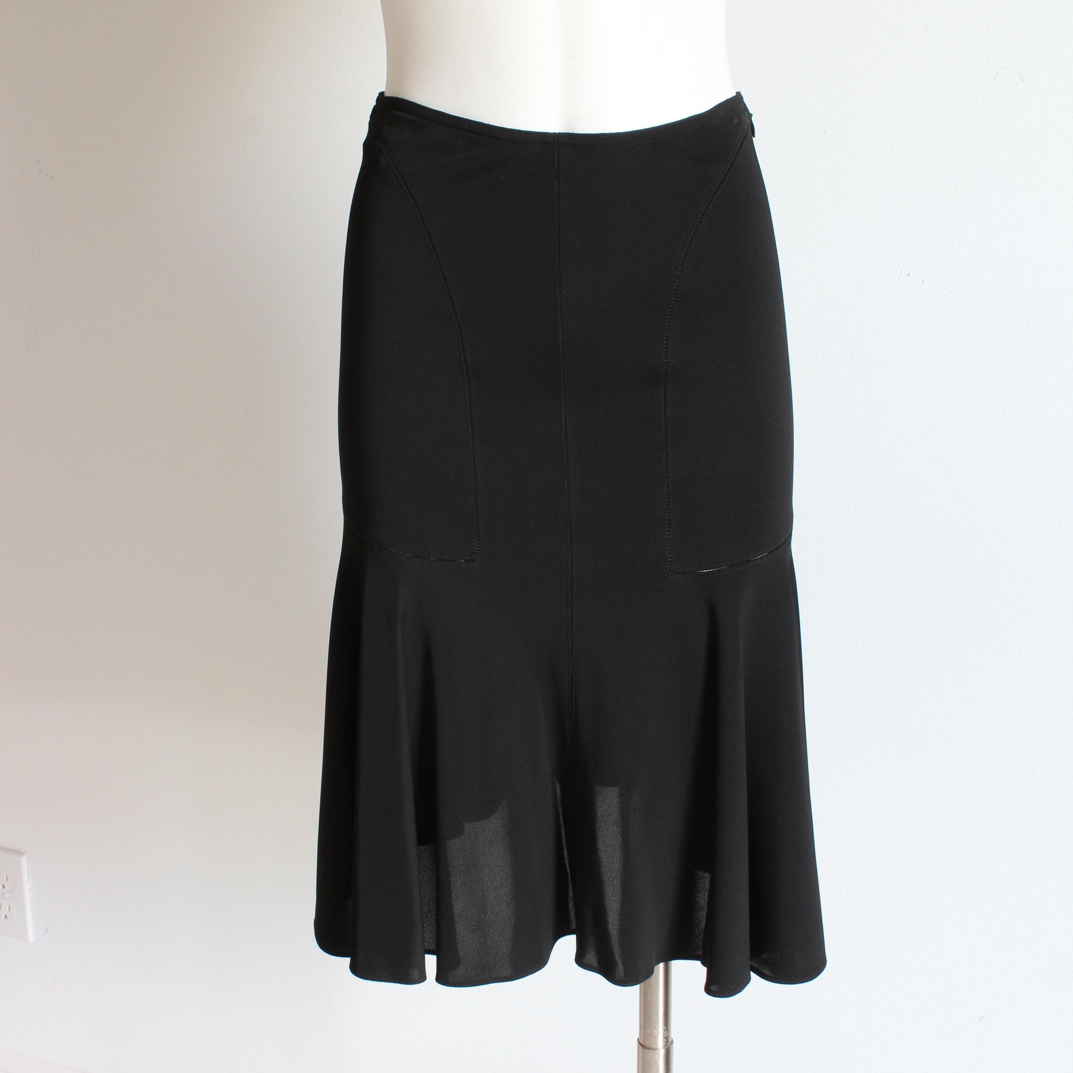 Authentic, preowned, vintage Azzedine Alaïa skirt with tulip hem, likely made in the 90s.  

Made from black viscose, it's unlined, fitted at the waist and hips and has decorative perforations in semi-circles at the front and back with a chic flared