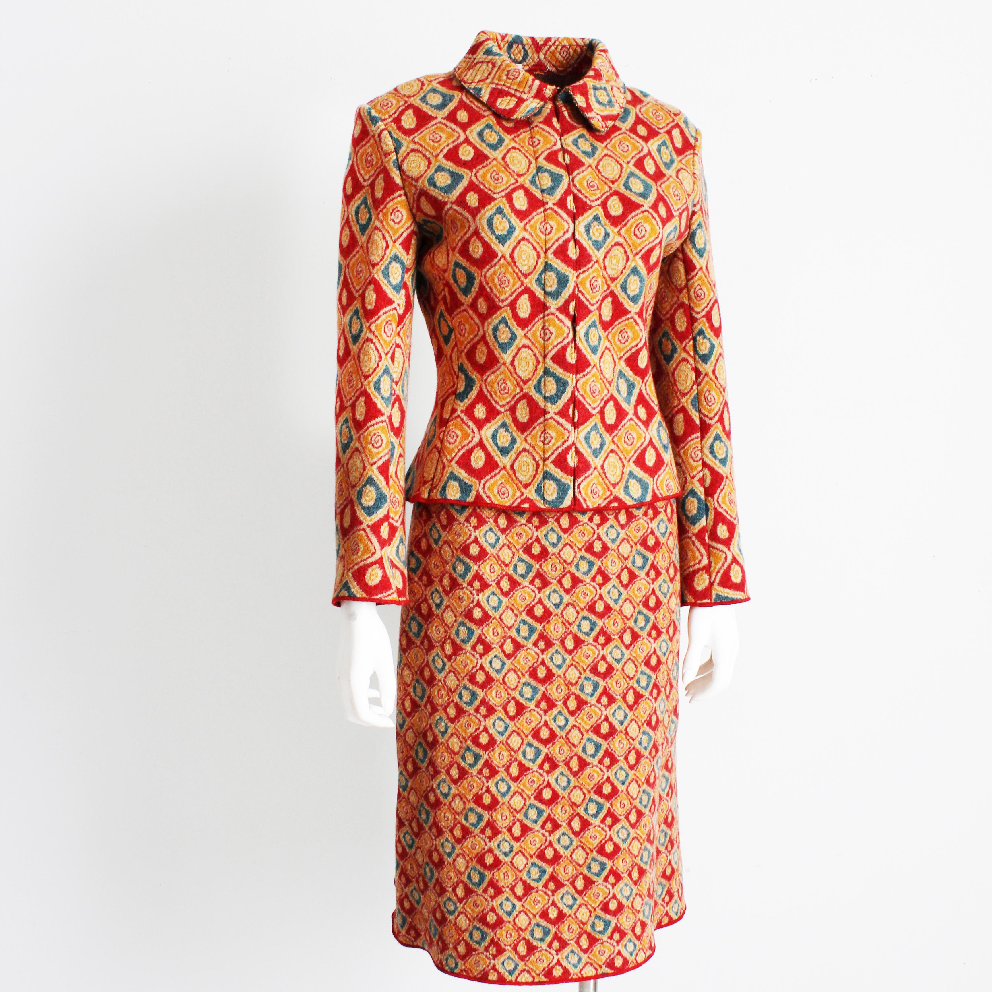 A unique, abstract Intarsia knit suit by Azzedine Alaïa, likely made in the late 90s or early 2000s.  Made from 100% new wool, the knit features abstract shapes in shades of red, blue and yellow, with a larger pattern on the jacket and a smaller