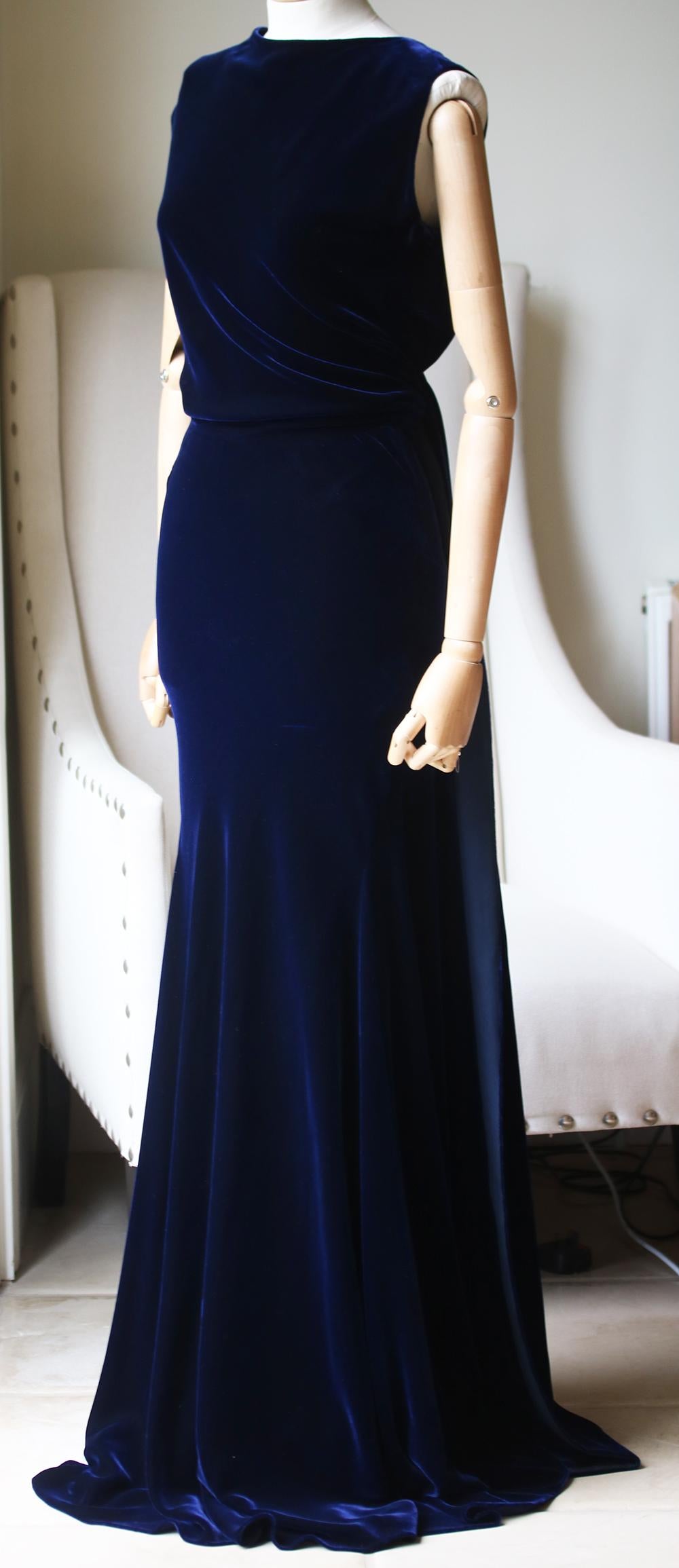 This rich navy-blue Alaïa sleeveless silk velvet gown is crafted in Italy from silk with a high draped neckline and concealed low-back. Toni Morrison once wrote that ‘velvet is like the world was just born. Clean and new and so smooth.’