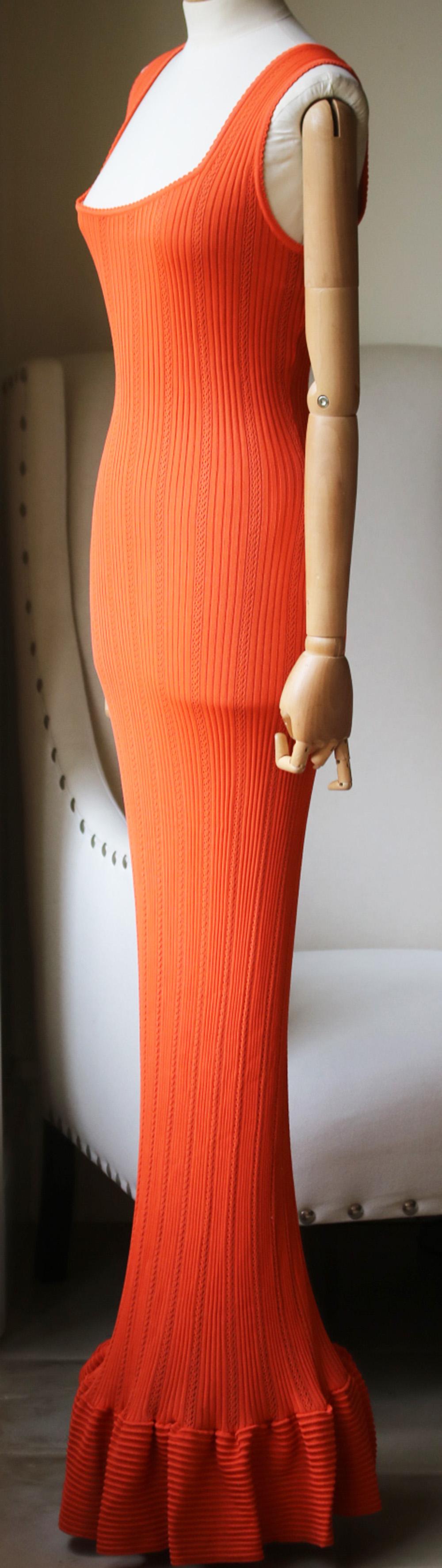 An incredibly elegant vintage orange dress by Azzedine Alaia. From the 1990's, this dress is seamless with a scoop neckline. The neckline flatters the bust and the cinched in waist hugs the hips to drape off into a long skirt. In rayon jersey