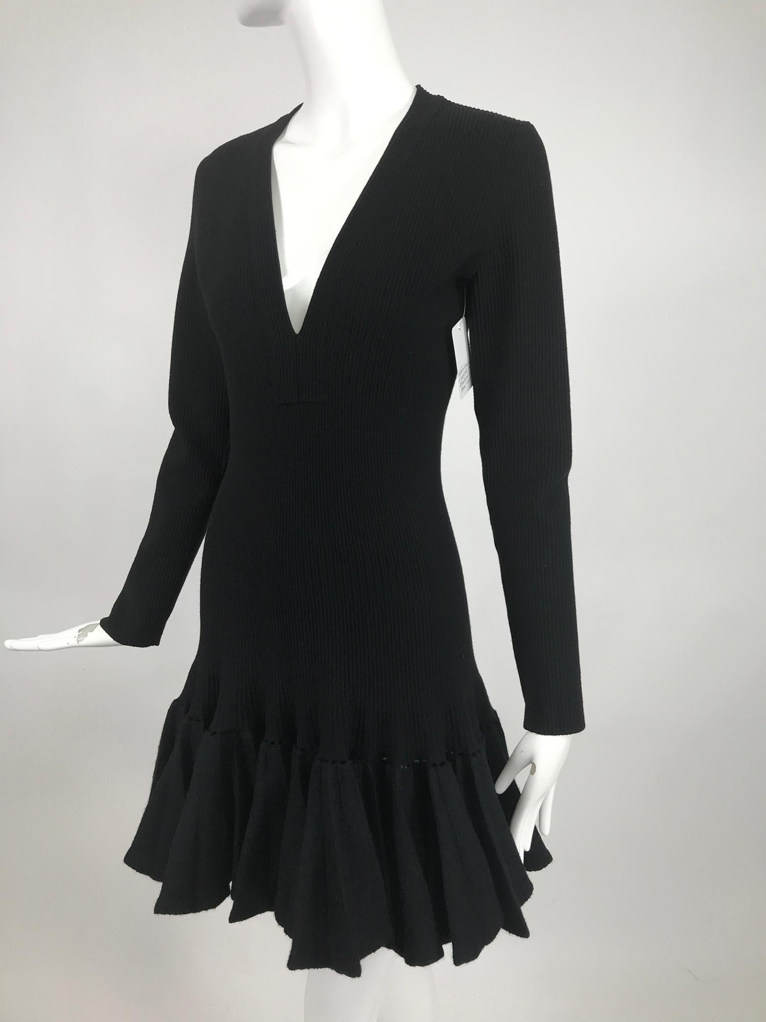 Azzedine Alaia black knit V neck dress with felted wool knife pleated circular hem. Long sleeve ribbed wool torso dress with a plunge v neckline and figure hugging shape. The hem is felted wool attached to the dress with an open stitch. The hem is