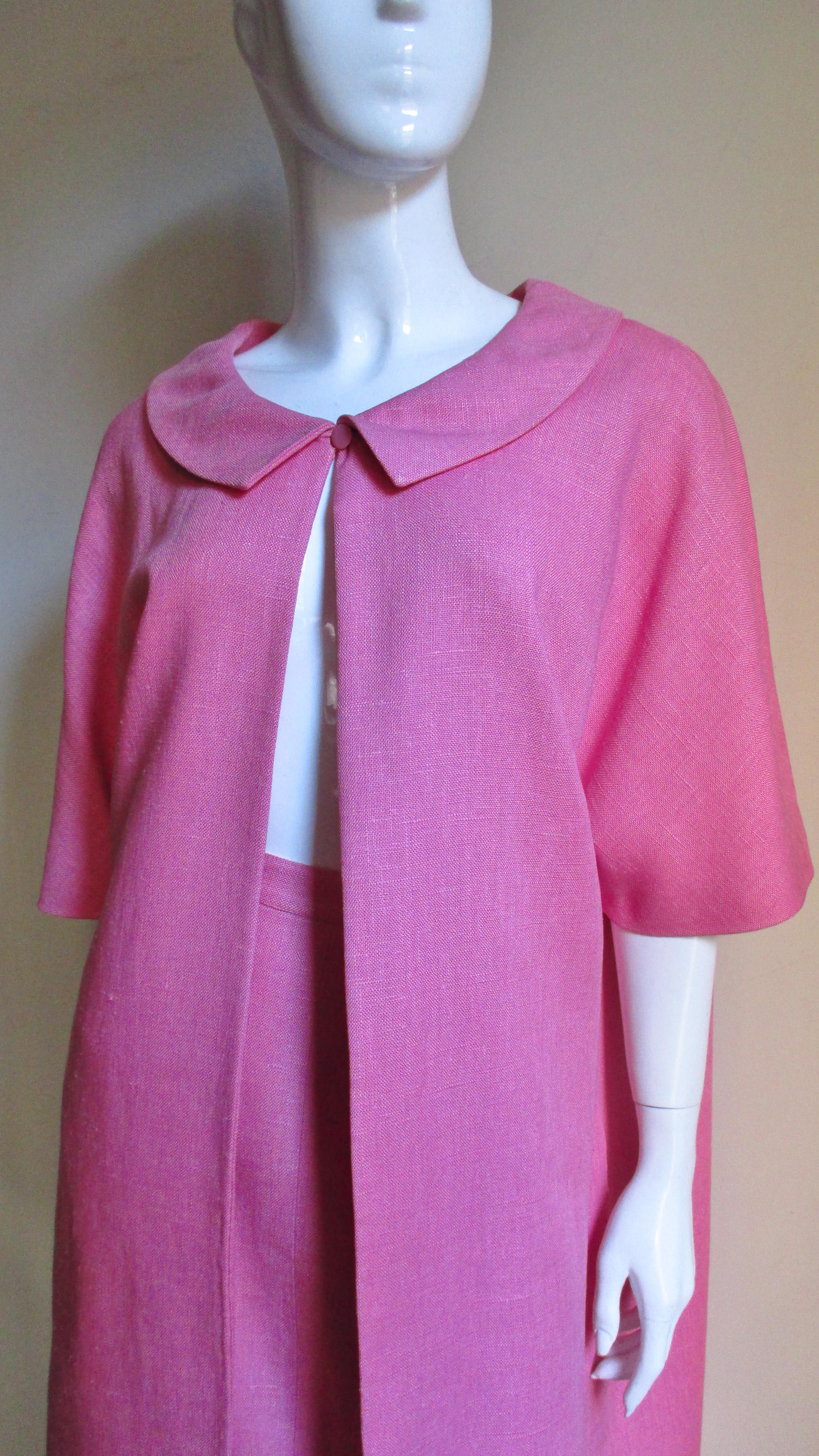A pretty pink linen skirt and coat set from B H Wragge consisting of a straight skirt with a small waistband and a coat with a collar, elbow length sleeves and side seam pockets. The coat is lined in white silk with matching pink abstract shapes