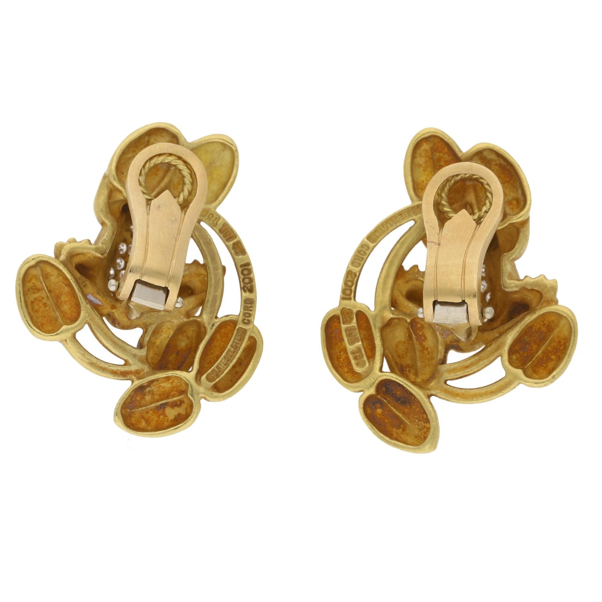 A quirky pair of Kieselstein Cord frog ear clips in 18ct yellow gold. 
Each earring comprises of a frog pave set with twenty three round brilliant cut diamonds across the back and as stylised eyes, surrounded by brushed gold lily pads. Stamped “B