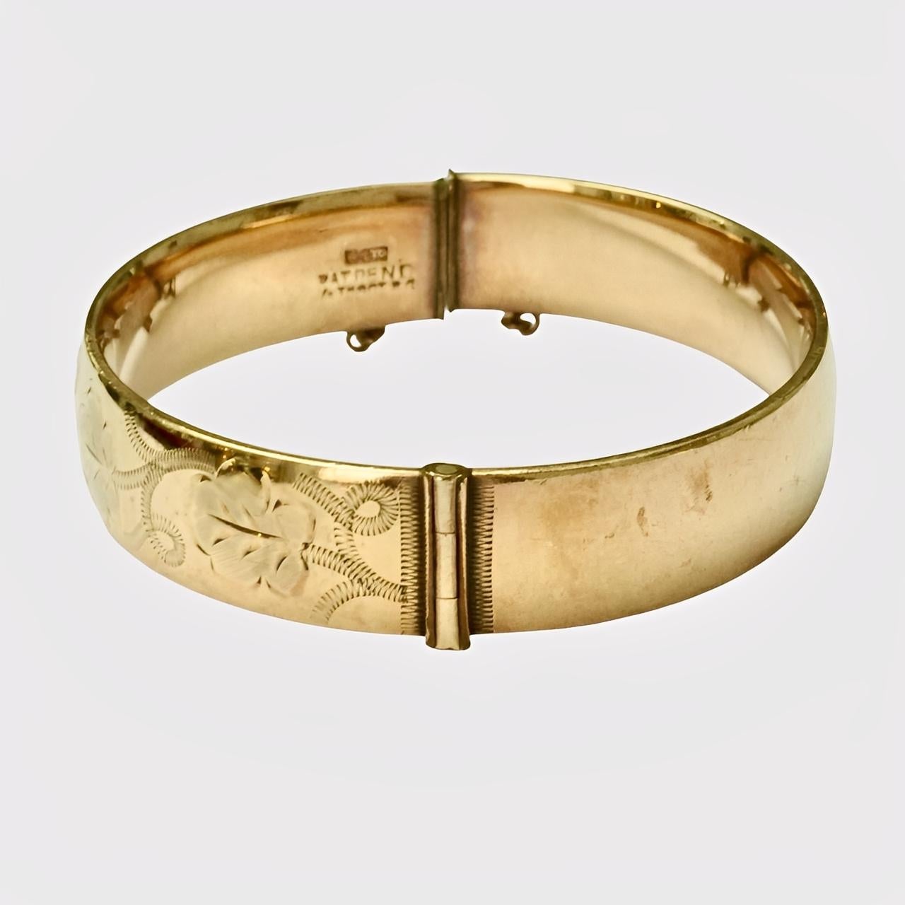 Meraviglioso braccialetto bangle con incisione a vortice in oro 9ct 1/5, con catena di sicurezza. Si apre con una chiusura a scorrimento. La chiusura è leggermente disallineata quando è chiusa, ma funziona bene. Il bracciale presenta dei graffi,