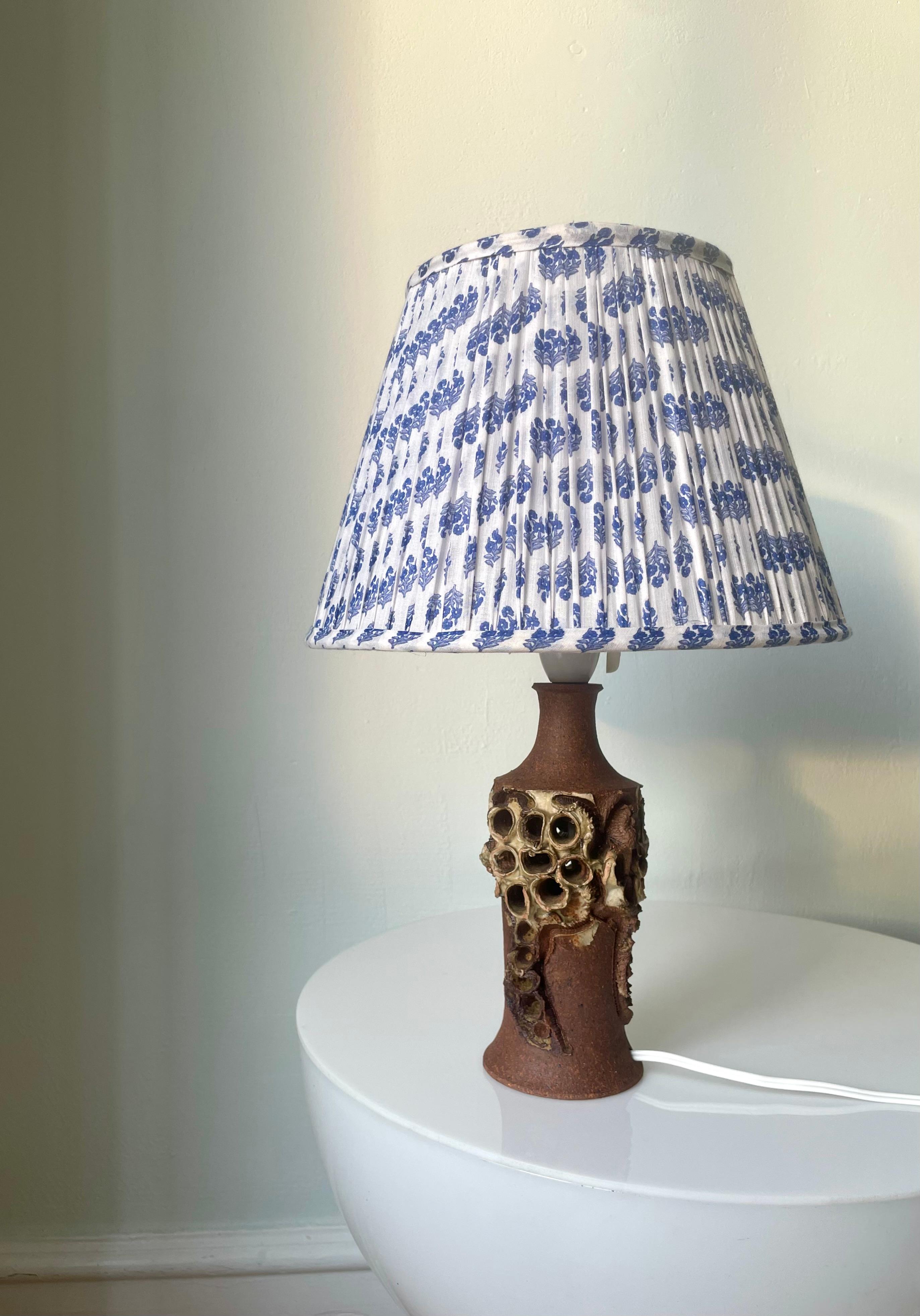 Unique Danish Expressionist stoneware table lamp handmade by experimental ceramic artist Bodil Marie Nielsen in the 1960s. Latte colored glaze mixed in with the raw terracotta clay decorated with Nielsen's signature brutalist organic shapes and