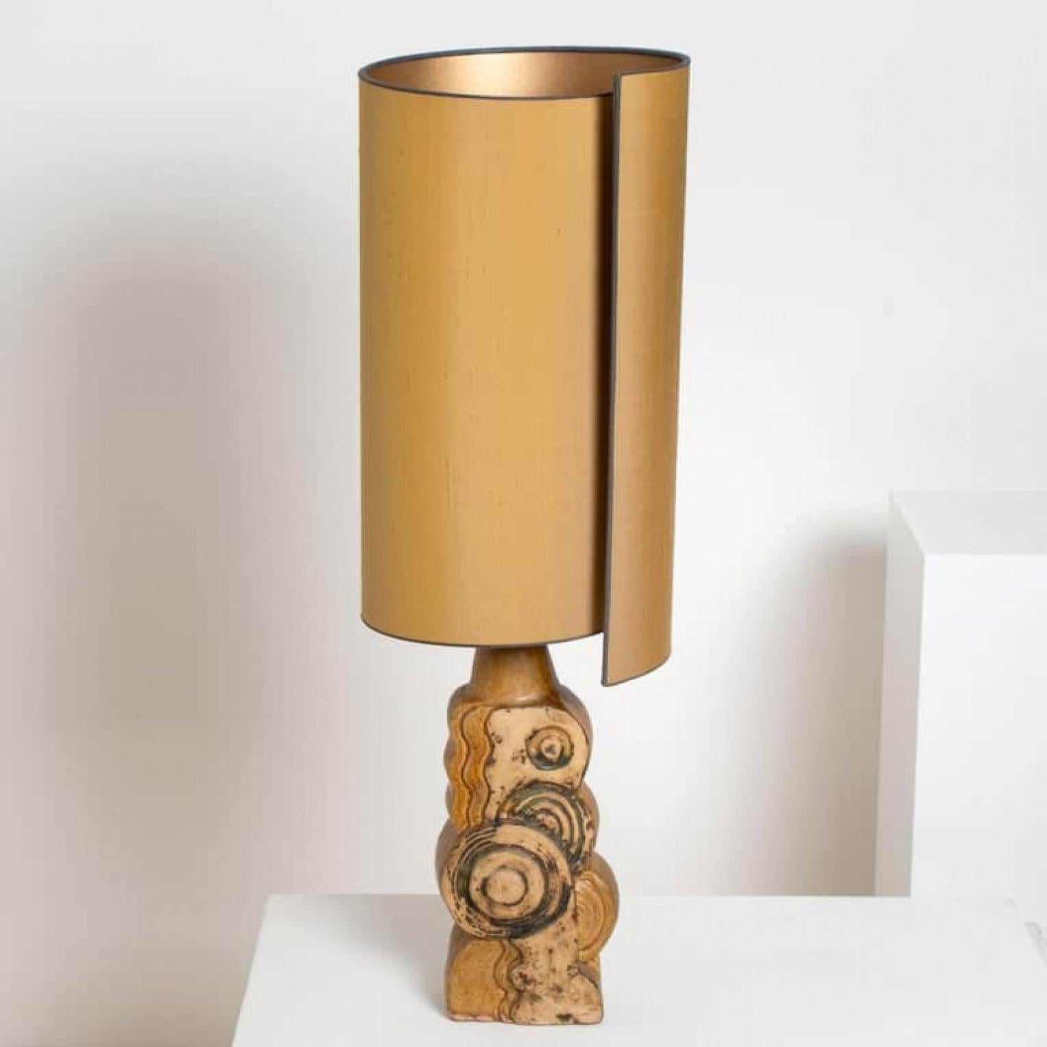 A rare ceramic table lamp by Bernard Rooke, England, 1960s. Sculptural piece, made of handmade ceramic elements in natural tones of terracotta and stone. With an exceptional custom made silk lamp shade by René Houben.

The lamp is in perfect vintage