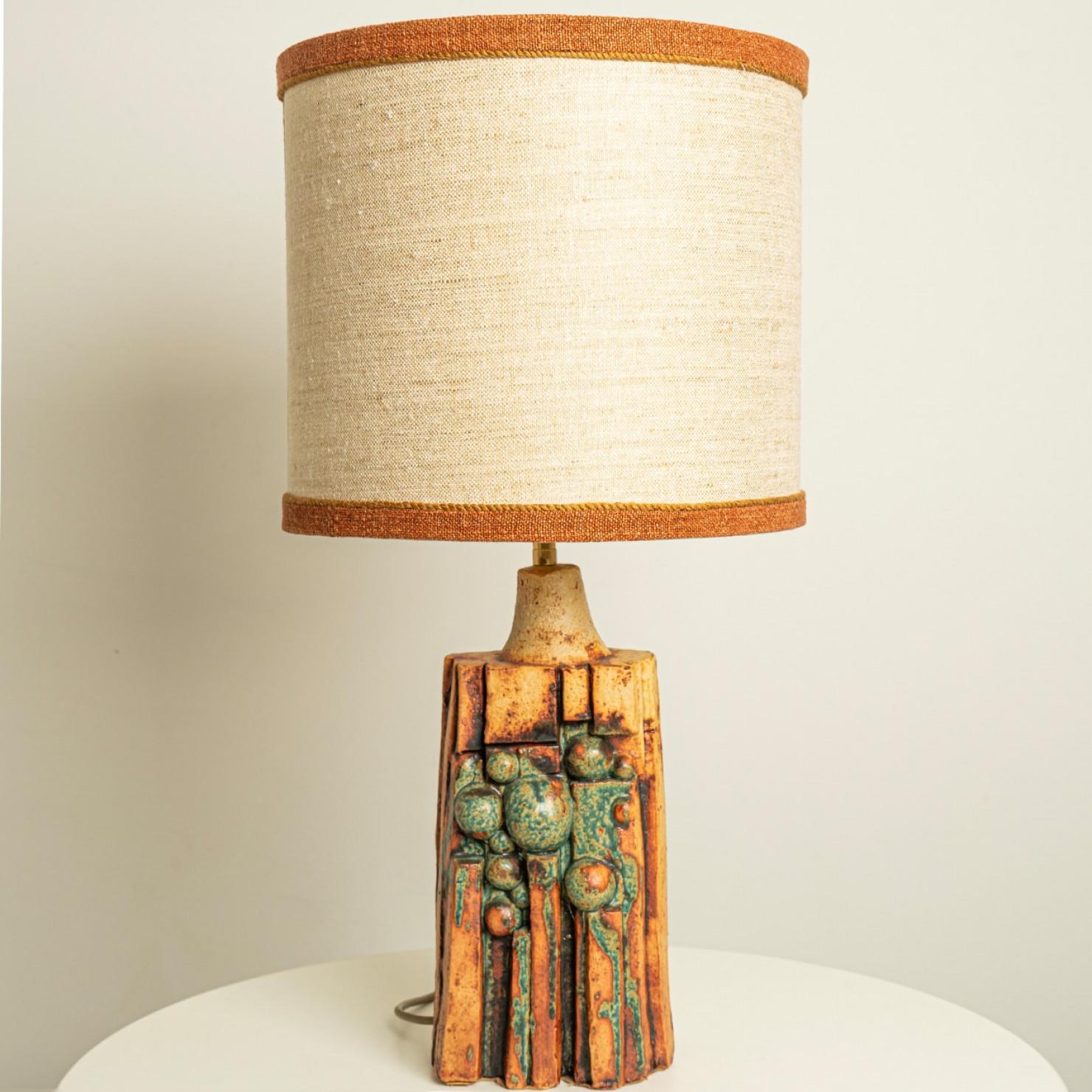 A rare ceramic table lamp by Bernard Rooke, England, 1960s. Sculptural piece, made of handmade ceramic in natural tones of terracotta and stone, with an l new custom made matching lamp shade by René Houben.

The lamp is in perfect vintage condition.