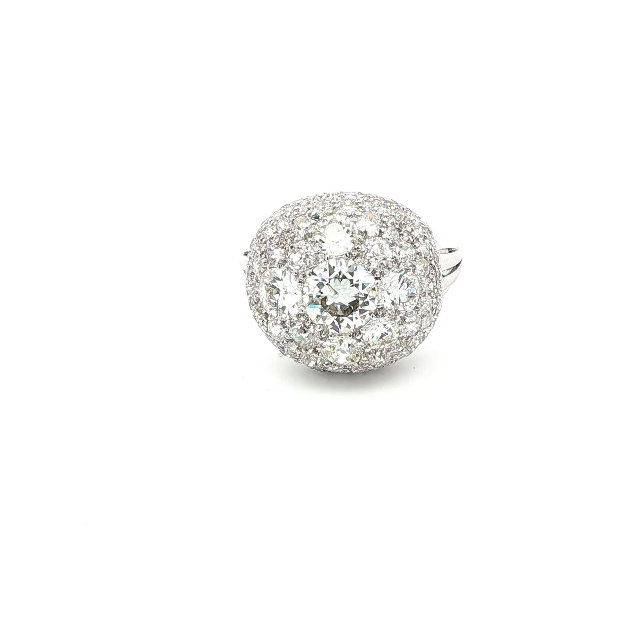 A stunning example of Art Deco glamour, this platinum dome cocktail ring dazzles with a spectacular 5.11 carats of diamonds. At its heart lies a luminous old European cut diamond of approximately 1.20 carats, graded G–H color and VS1–VS2 clarity.