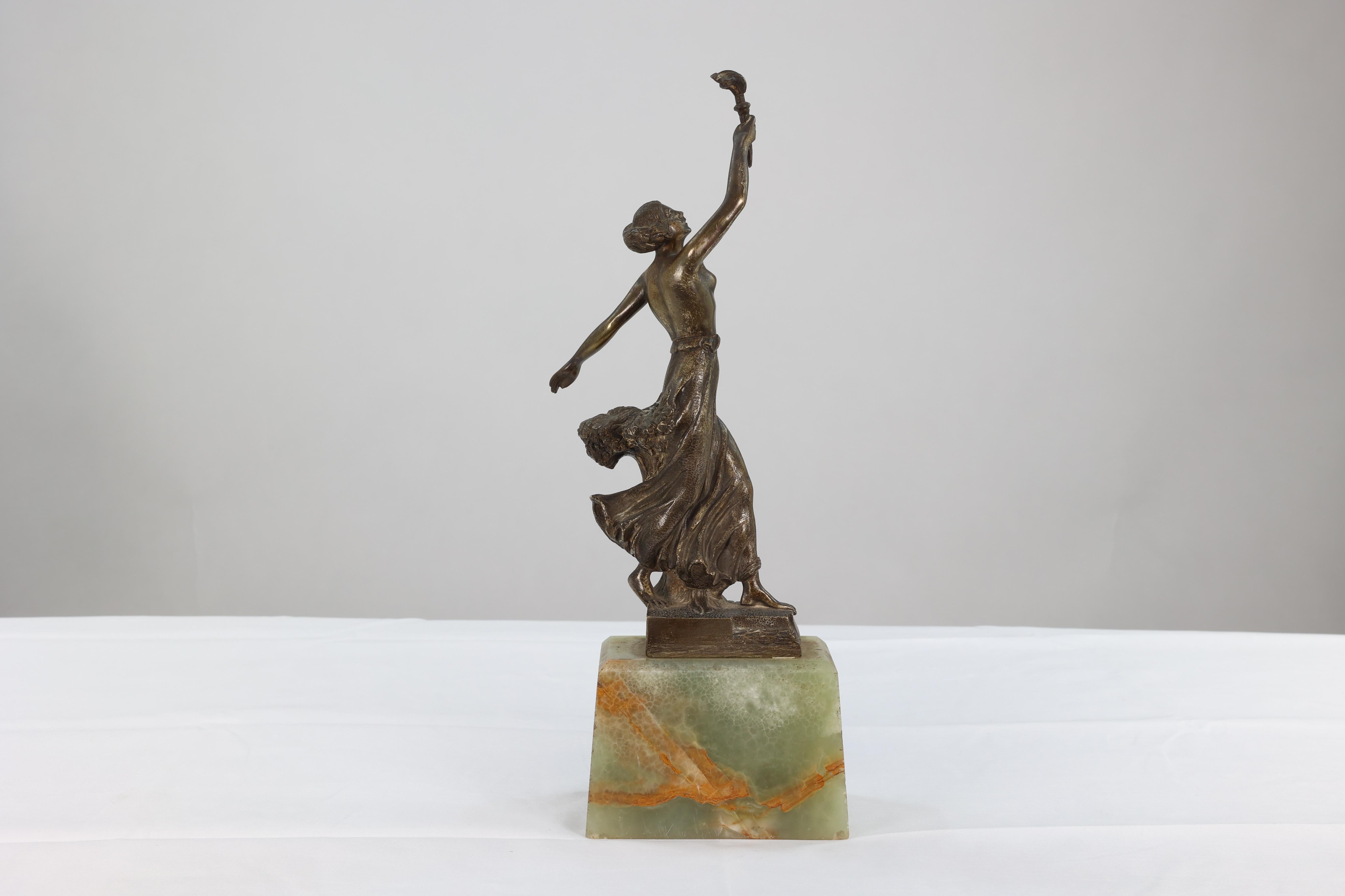 B.V. Fernandez, an Art Deco bronze figure, of a bare-breasted torch bearer, impressed 'Fernandez' and 'Uruguay 252,' on a green onyx base.
   