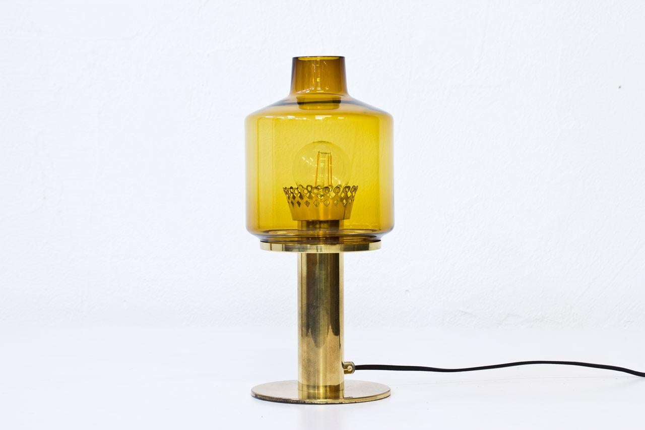 Table lamp model B 102 made of handblown glass in an amber color. The piece features a stem and base in polished brass, a light switch on the cord and new wiring.