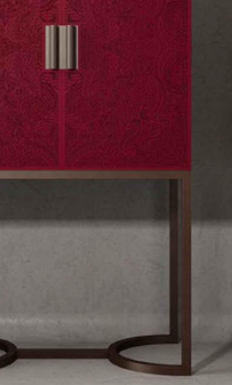 Part of the Bluemoon collection, this exquisite bar cabinet will elevate any dining room bar with its bold colors and modern lines. The square lacquered wood top features an eye-catching crimson color with paisley engravings and a velvet-like finish