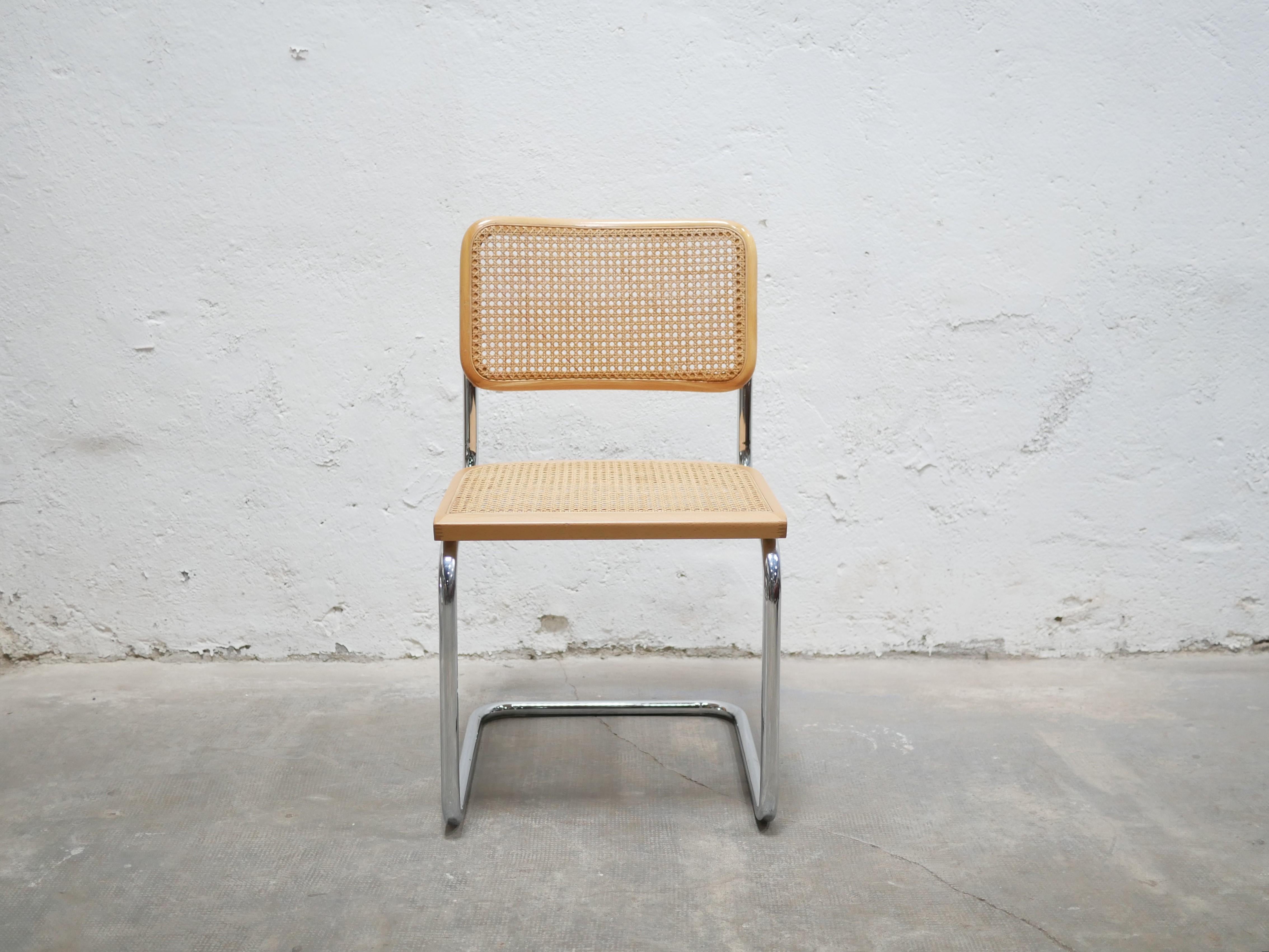 Chaise conçue par Marcel Breuer, modèle B32, datant des années 80.

Piétement tubulaire en acier chromé, assise et dossier cannés avec structure en bois naturel. Cette chaise est une pièce emblématique de l'histoire du modernisme et du Bauhaus.