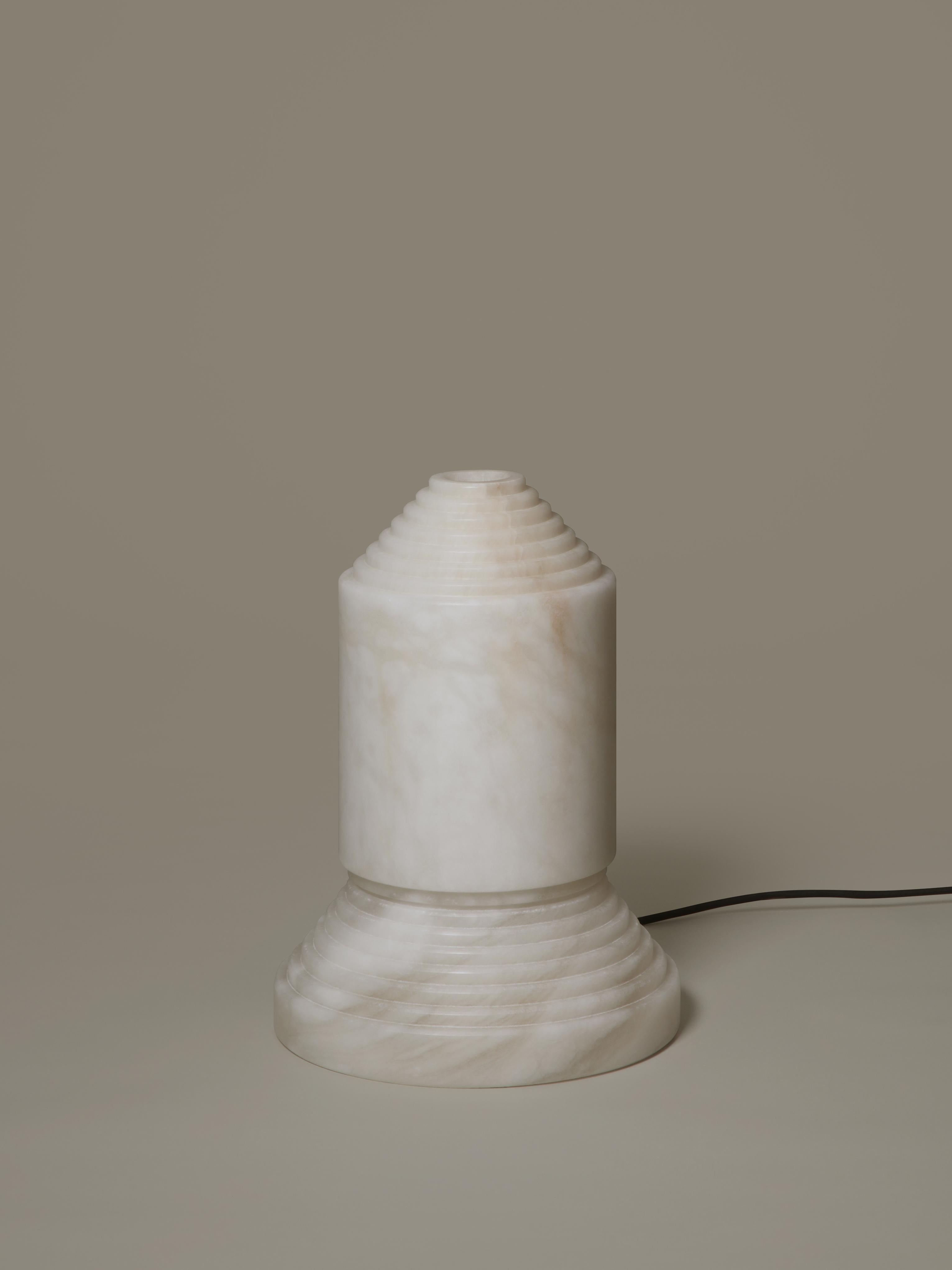 Babel alabaster table lamp by Àngel Jové.
Dimensions: D 30 x H 40.5 cm.
Materials: Alabaster.

Babel, whose name comes from the biblical story of the unfinished tower, is both a sturdy sculpture and a lamp apt for night-time intimacy. The use of